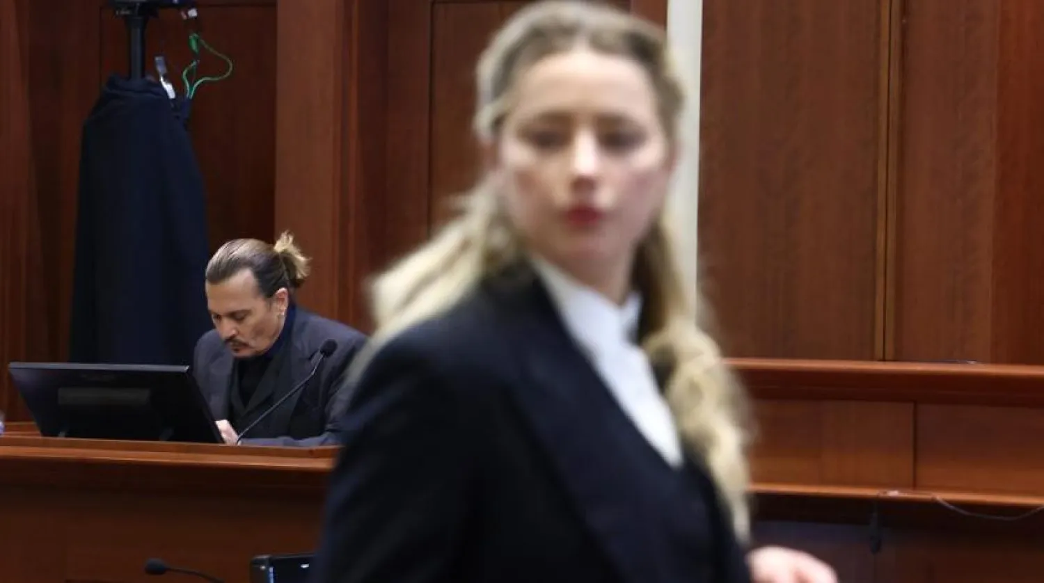 US actress Amber Heard (R) speaks to her legal team as US actor Johhny Depp (L) returns to the stand after a lunch recess during the 50 million US dollar Depp vs Heard defamation trial at the Fairfax County Circuit Court in Fairfax, Virginia, April 21, 2022. (AFP)
