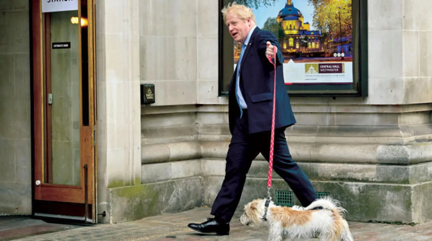بوريس جونسون مصطحباً كلبه إلى مركز اقتراع في لندن أمس (أ.ف.ب)