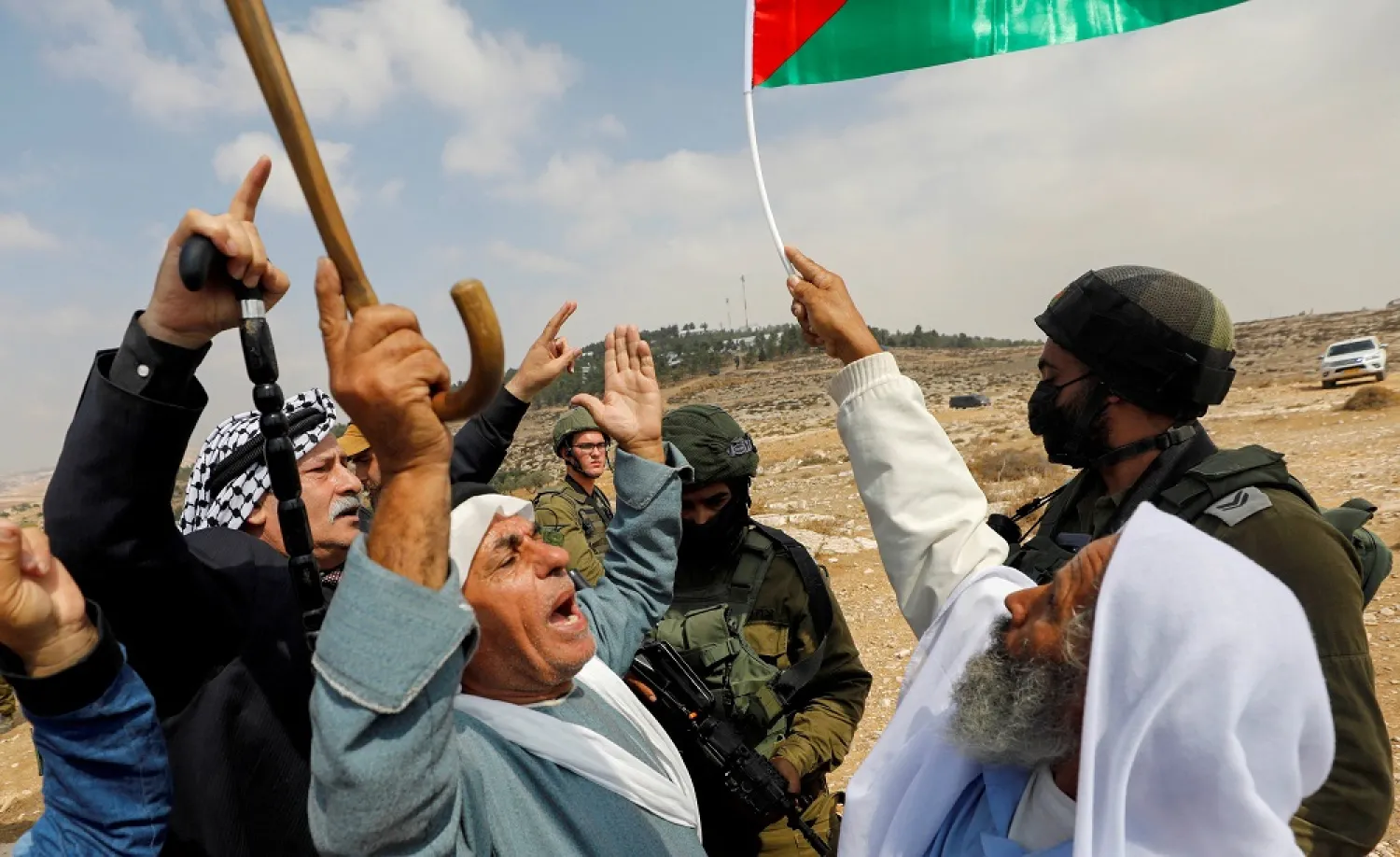 Palestinian demonstrators gesture next to Israeli forces during a protest against Israeli settlements in Masafer Yatta, in the Israeli-occupied West Bank, October 2, 2021. (Reuters)