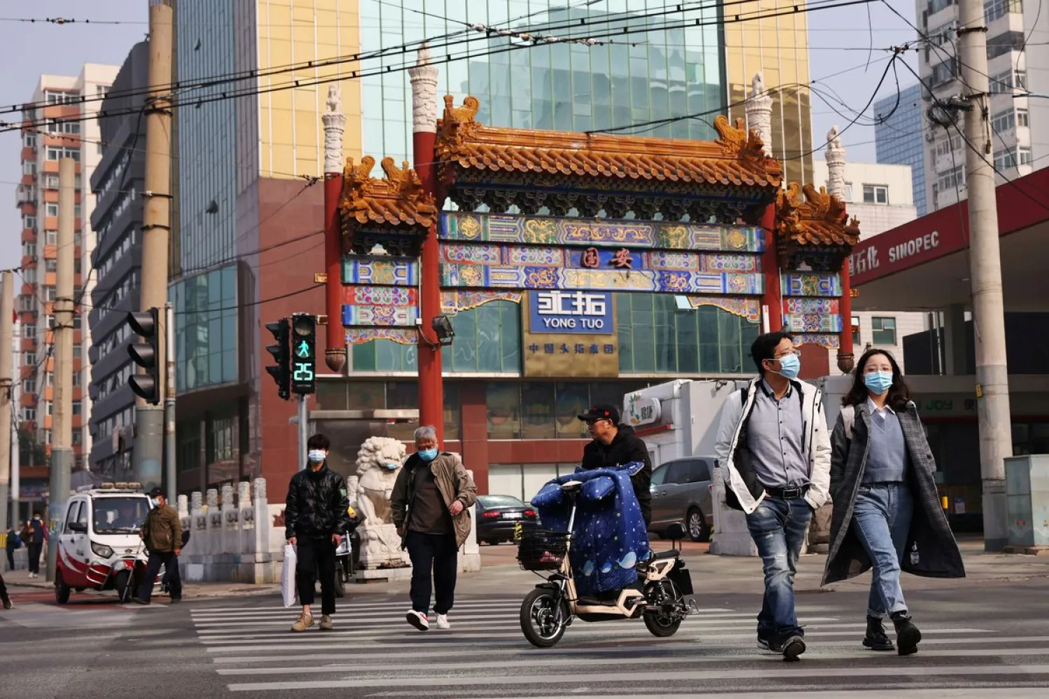 People wearing face masks cross a street in Beijing, China. Reuters file photo