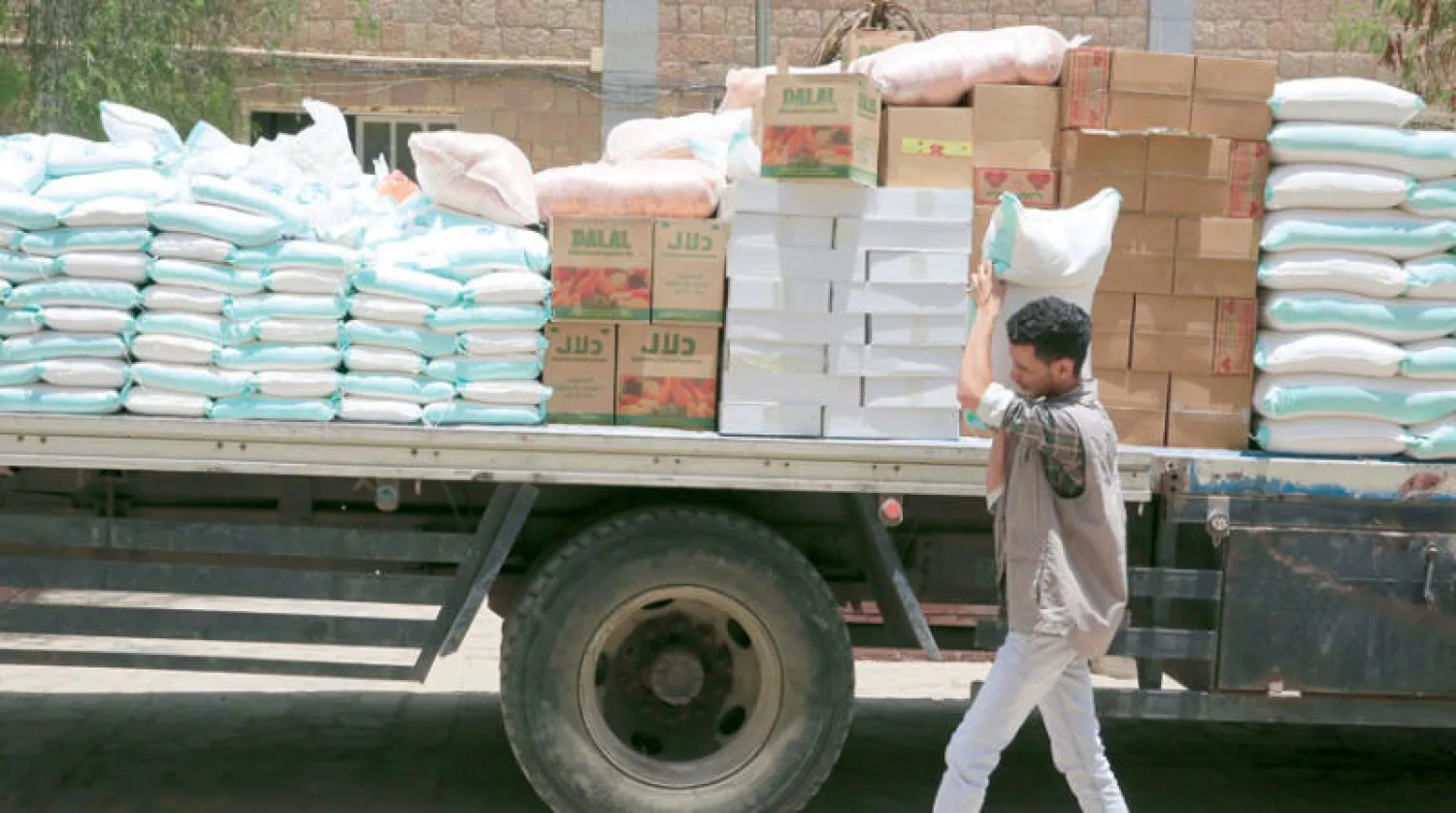 عامل يحمل مساعدات غذائية في صنعاء (إ.ب.أ)