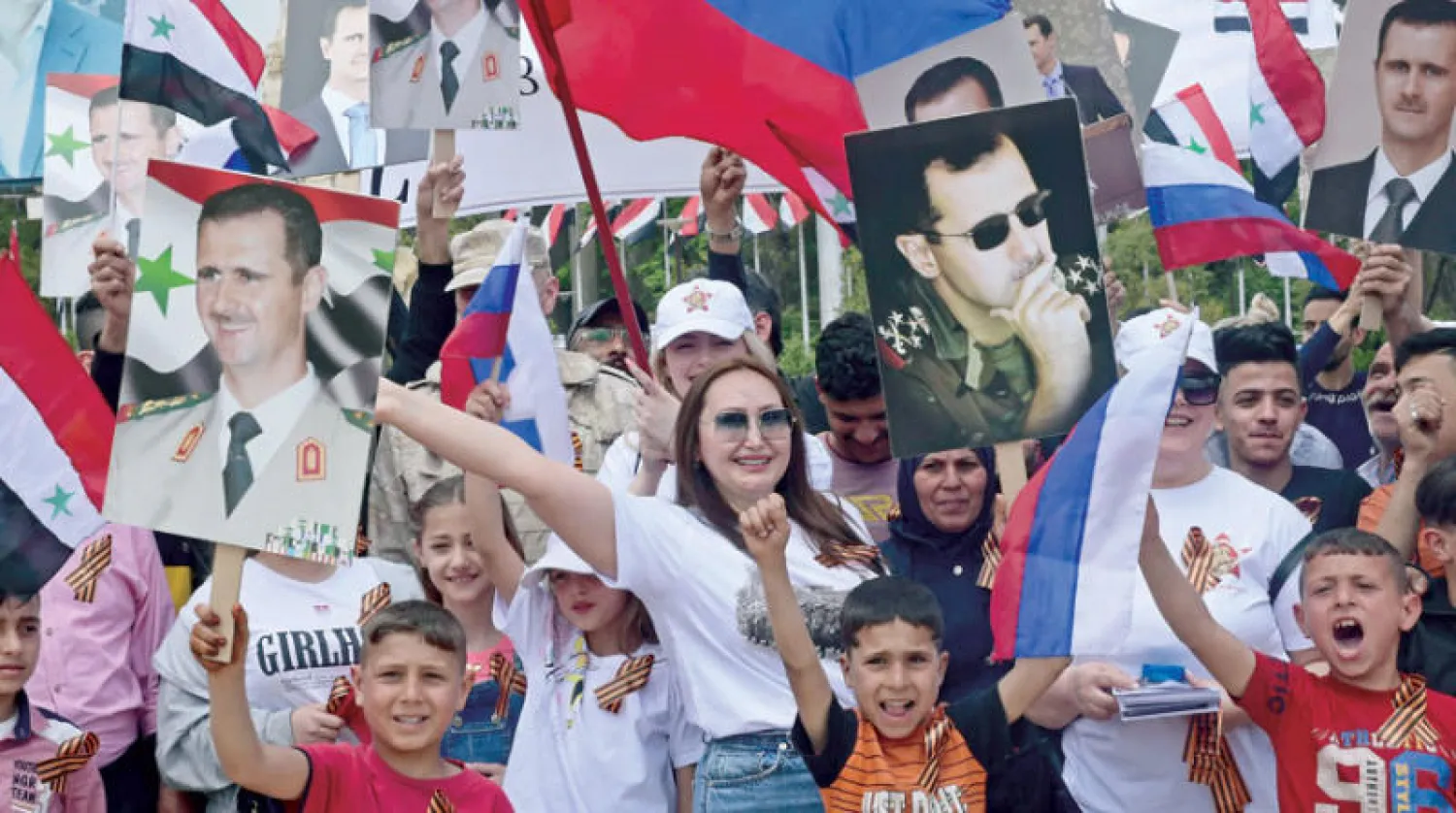موالون للنظام السوري يحيون {عيد النصر} الروسي في حلب أول من أمس (أ.ف.ب)