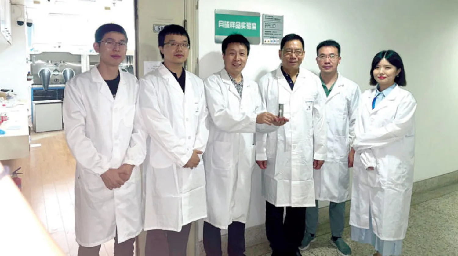 فريق البحث في جامعة نانجينغ ممسكاً بعينة تربة القمر