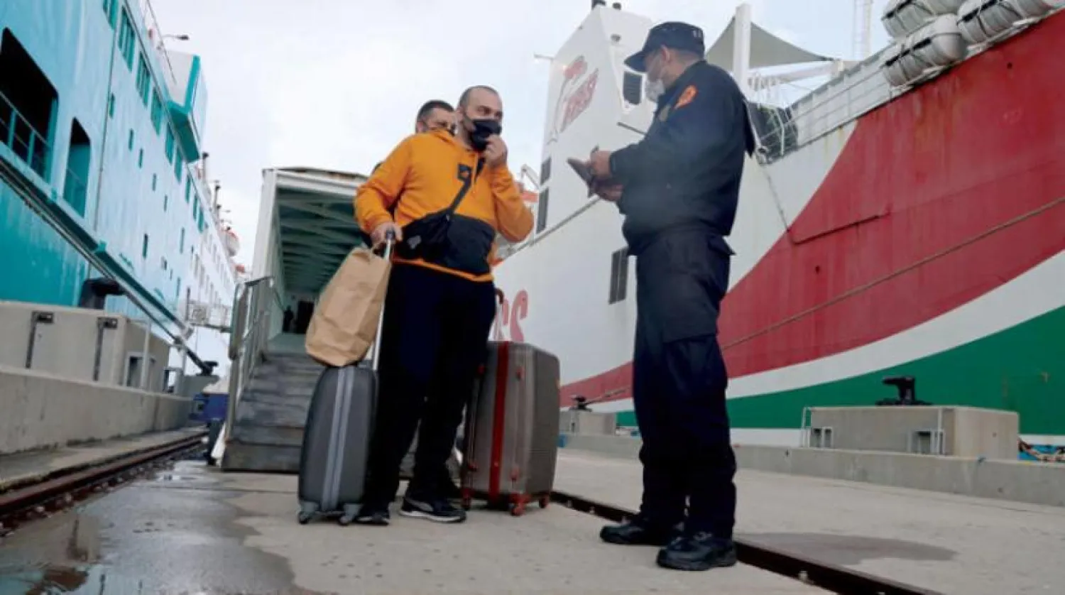 A Moroccan policeman checks the identity papers of travelers who arrived by ship from Spain at the port of Tangiers on April 12. (AFP) 