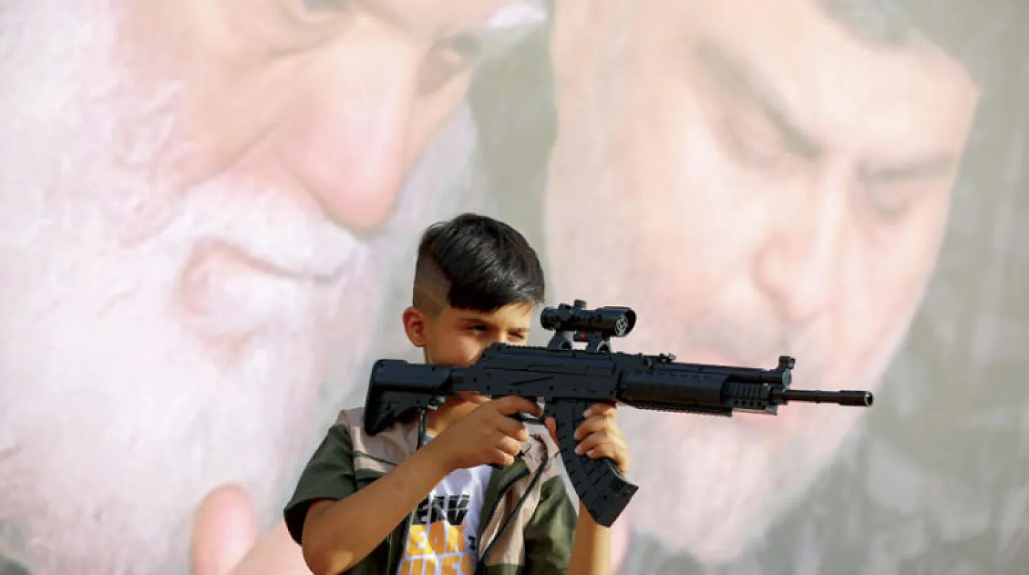 طفل يلهو ببندقية ألعاب في متنزه بمدينة الصدر شرق بغداد يوم 3 مايو الحالي (د.ب.أ)