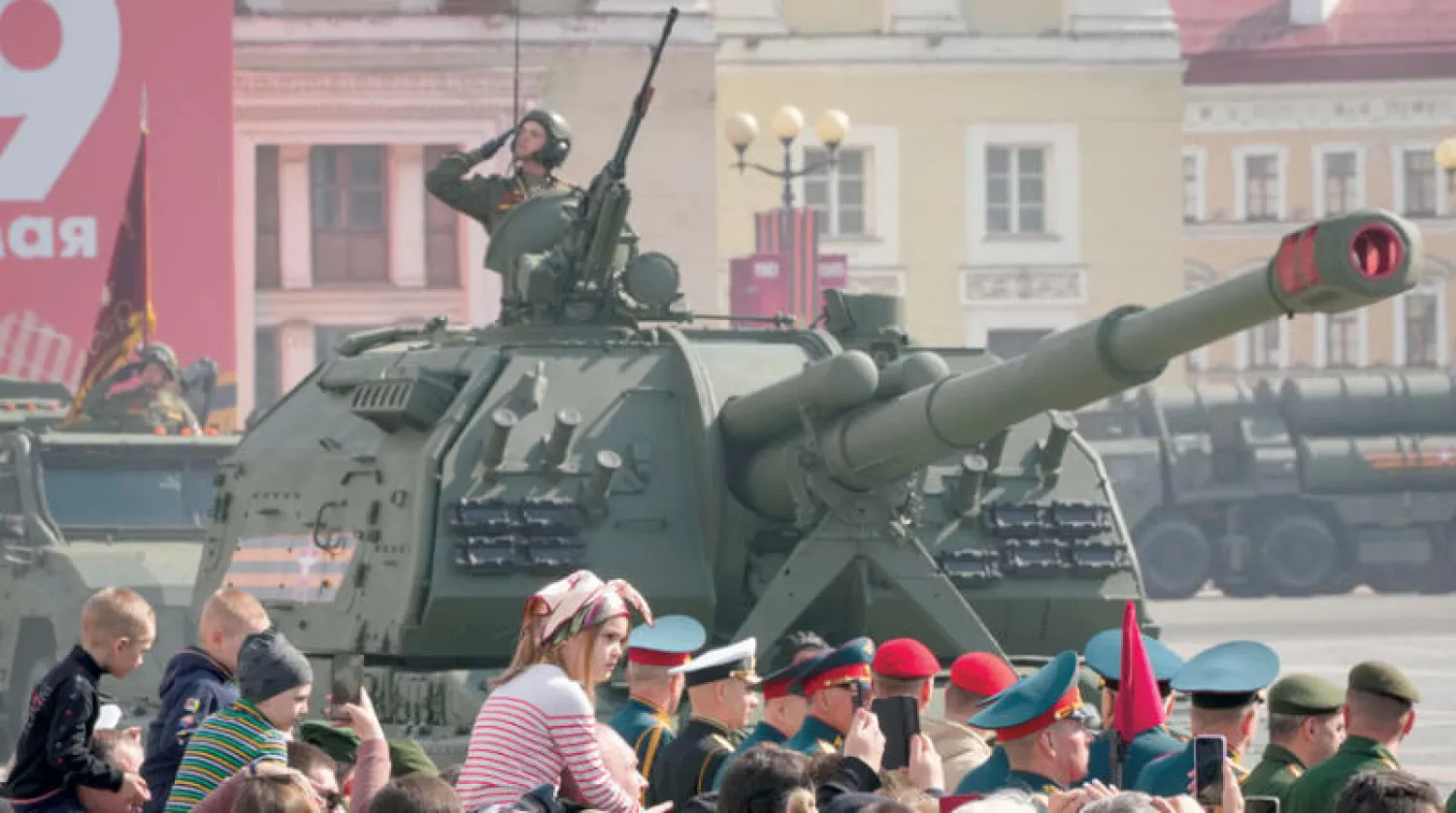 عشرات الروس يتابعون استعدادات العرض العسكري في عيد النصر بموسكو أمس (أ.ب)