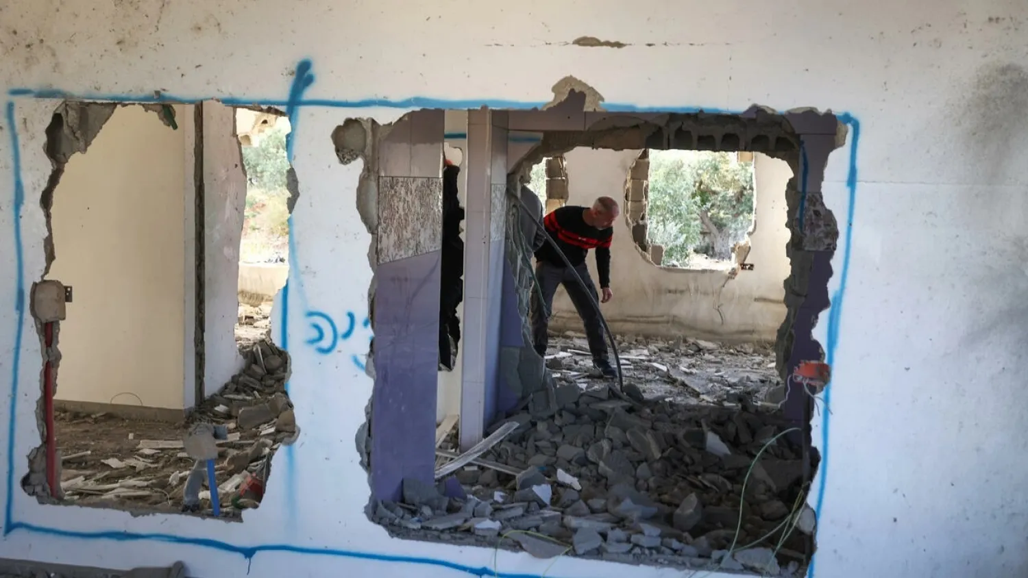 A Palestinian man inspects the home of Omar Jaradat demolished by Israeli security forces after they accused him of killing a Jewish settler. (AFP)