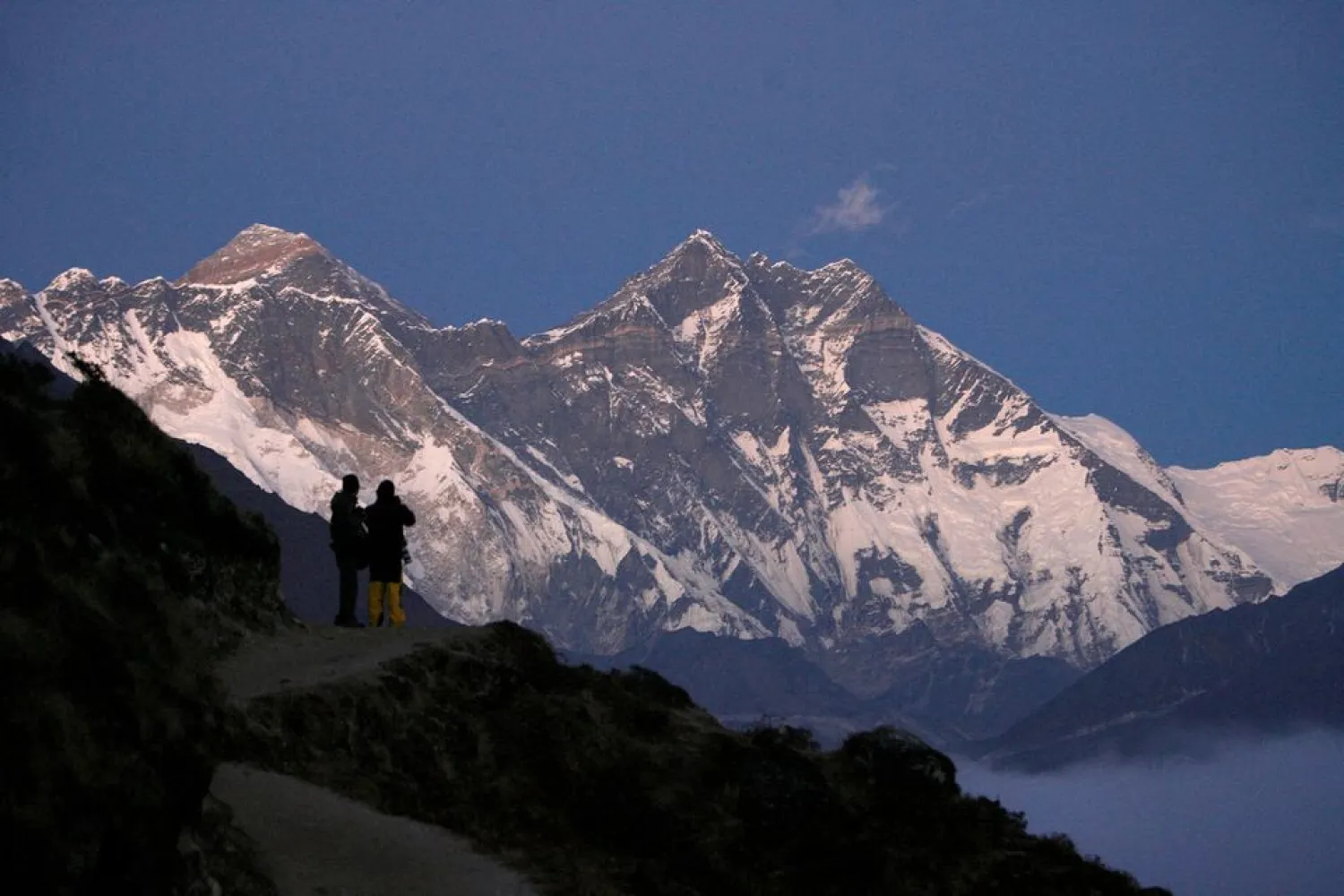 Travelers enjoy the the view of Mount Everest at Syangboche in Nepal December 3, 2009. REUTERS/Gopal Chitrakar/File Photo