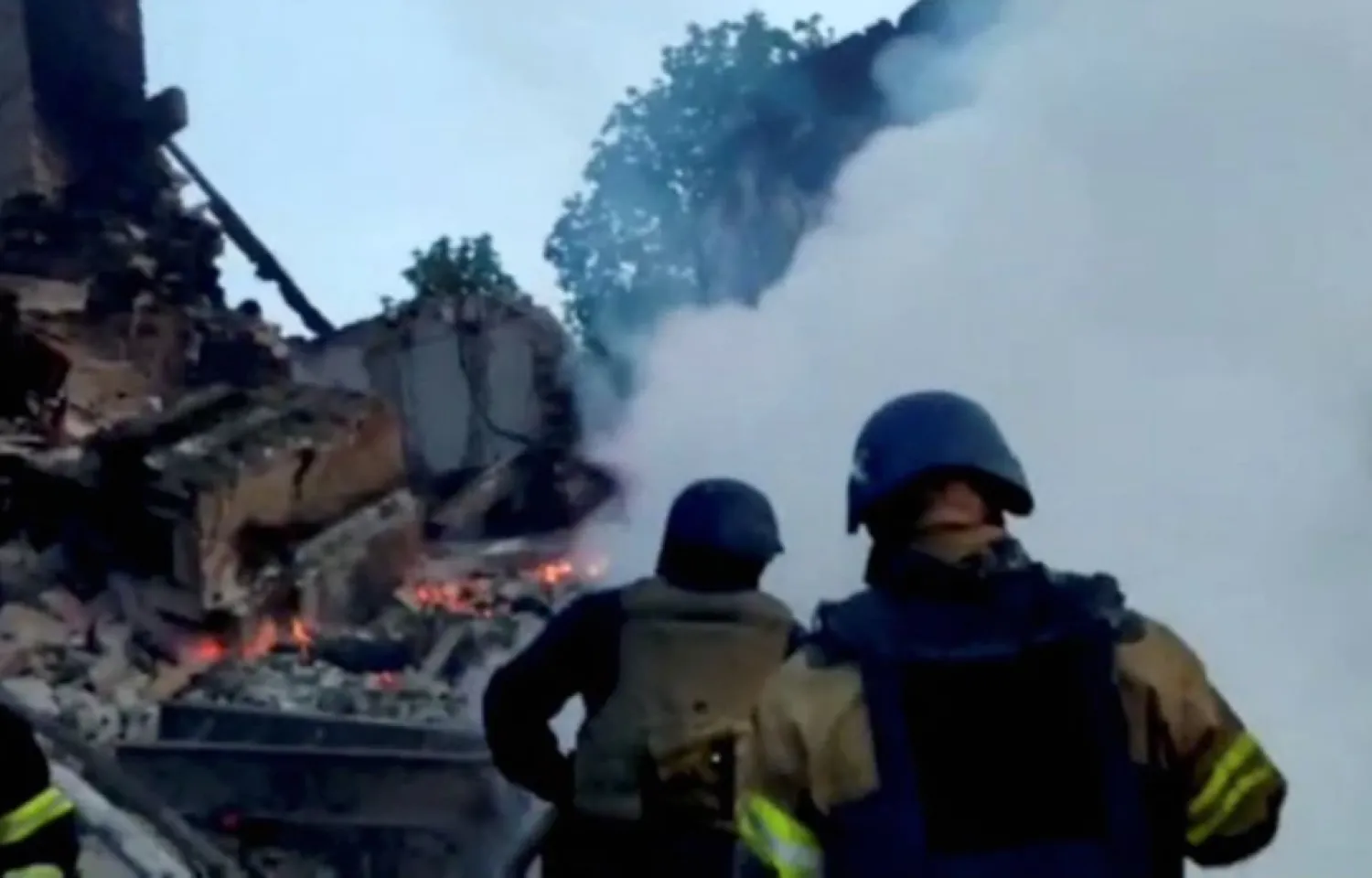 Emergency crew tend to a fire near a burning debris, after a school building was hit as a result of shelling, in the village of Bilohorivka, Luhansk, Ukraine, May 8, 2022. Luhansk Regional Military-Civil Administration/Handout via REUTERS