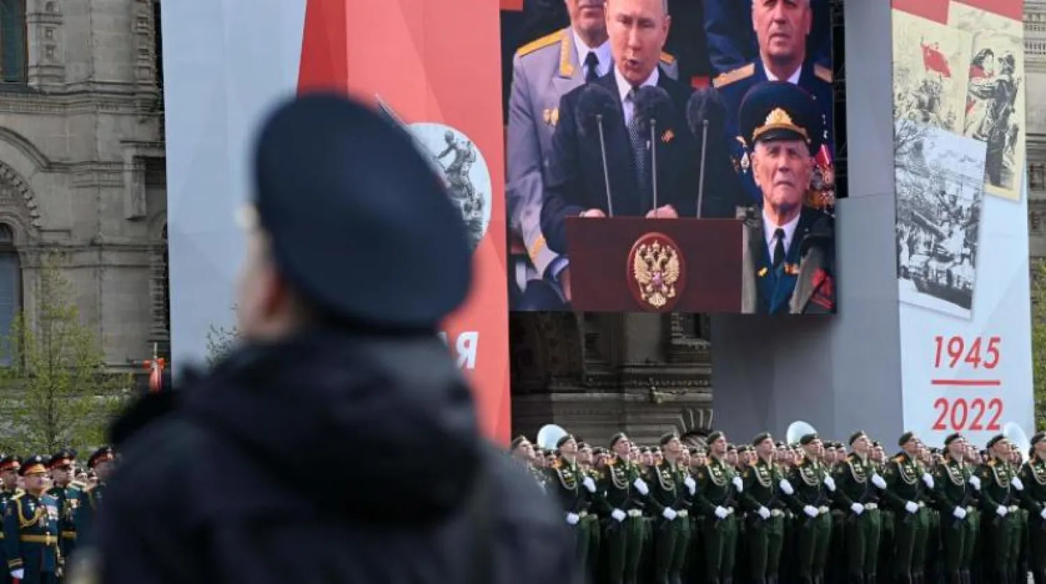 A screen shows Russian President Vladimir Putin giving a speech as servicemen line up on Red Square during the Victory Day military parade in central Moscow on May 9, 2022. (Photo by Kirill KUDRYAVTSEV / AFP)