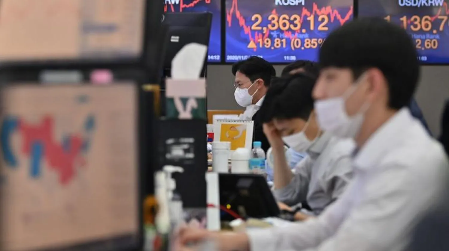 File: Traders looking at stock exchange graphs. AFP/Jung Yeon-je