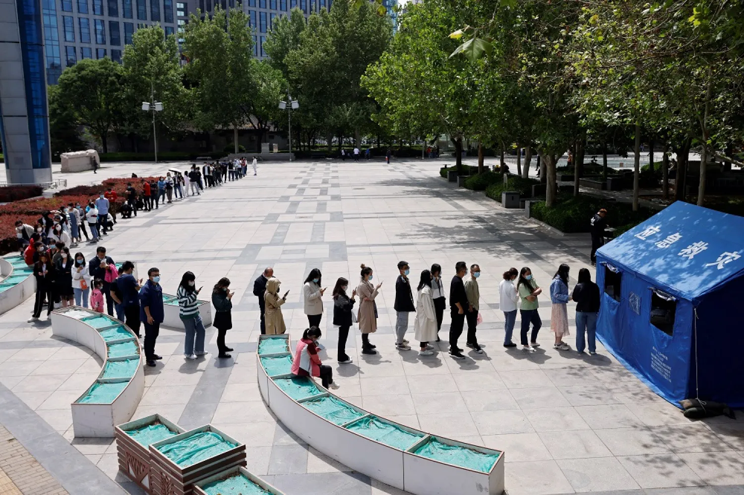 People line up at a makeshift nucleic acid testing site to get tested for the coronavirus disease (COVID-19) in Haidian district of Beijing, China May 9, 2022. (Reuters)