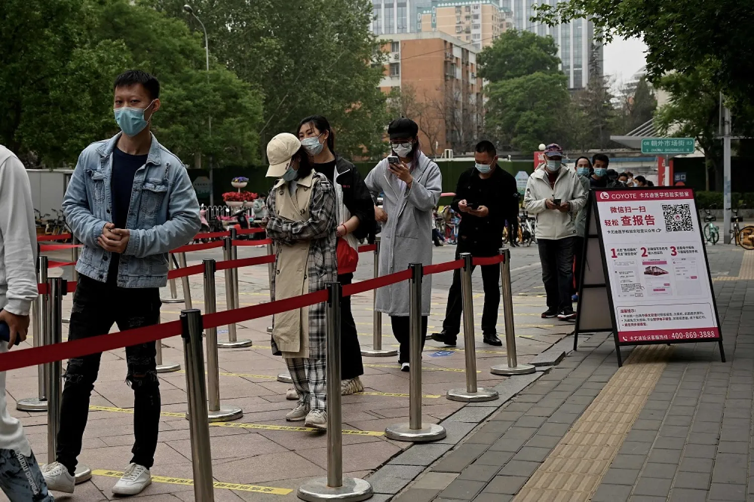 People queue to get a swab test for the Covid-19 coronavirus at a swab collection site in Beijing on May 10, 2022. (AFP)