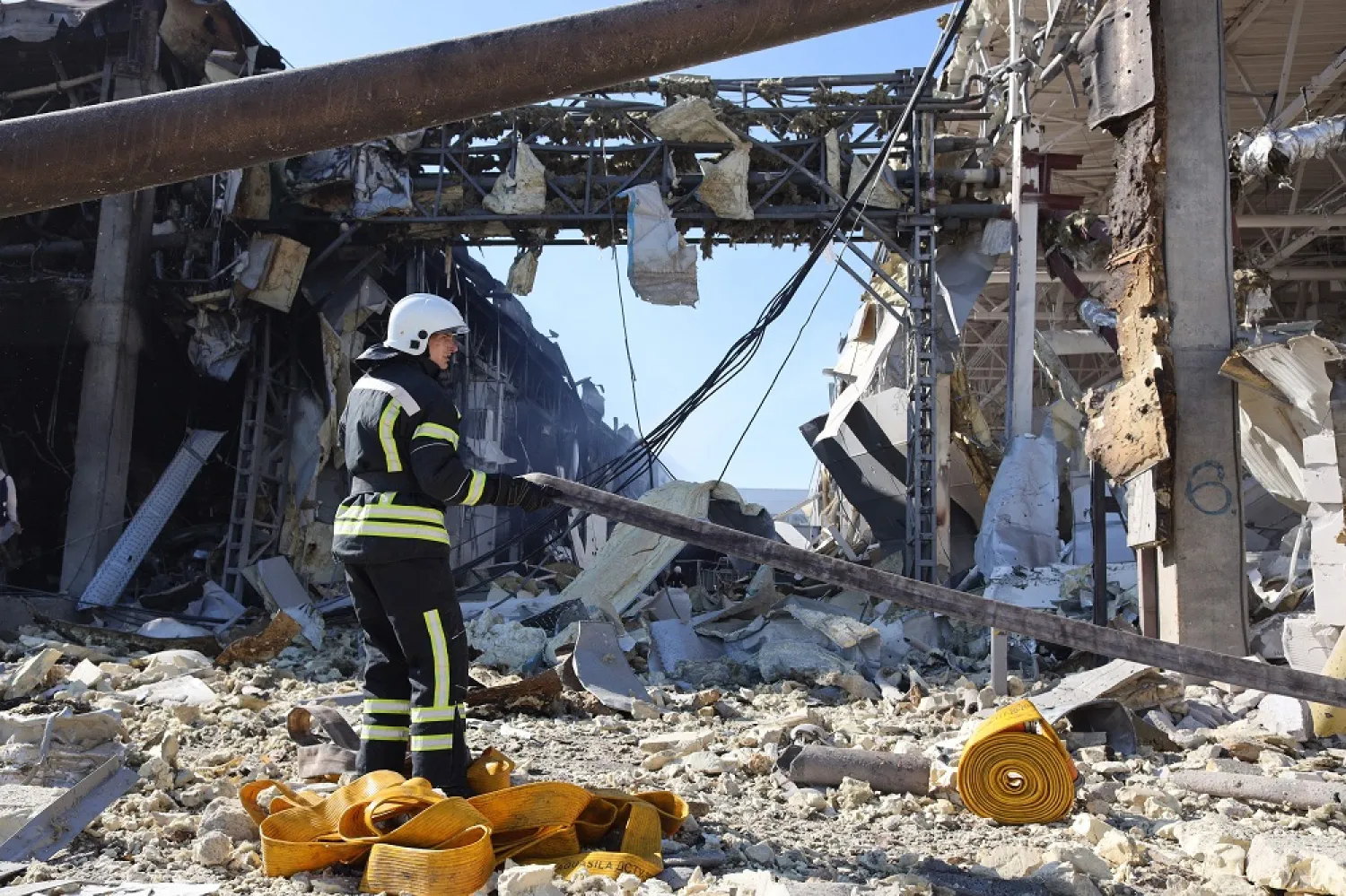 A rescue worker gestures in front of the shopping and entertainment center in the Ukrainian Black Sea city of Odesa on May 10, 2022, destroyed after Russian missiles strike late on May 9, 2022. (AFP)
