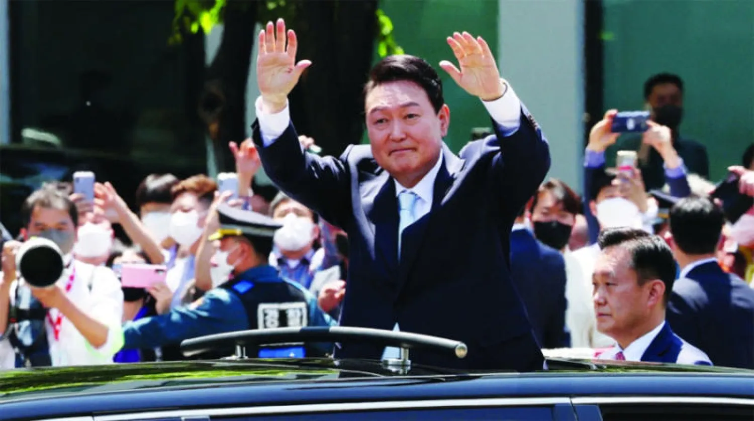 رئيس كوريا الجنوبية يون سوك يول يحيي مؤيديه عقب تنصيبه في الجمعية الوطنية بسيول أمس (رويترز)