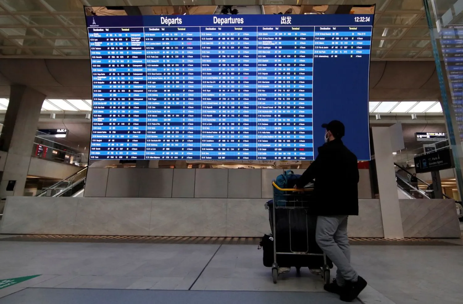 A passenger looks at a departures board with cancelled flights from Paris to London and Bristol at Paris Charles de Gaulle airport in Roissy near Paris, amid the spread of the coronavirus disease (COVID-19) in France, December 21, 2020. REUTERS/Gonzalo Fuentes

