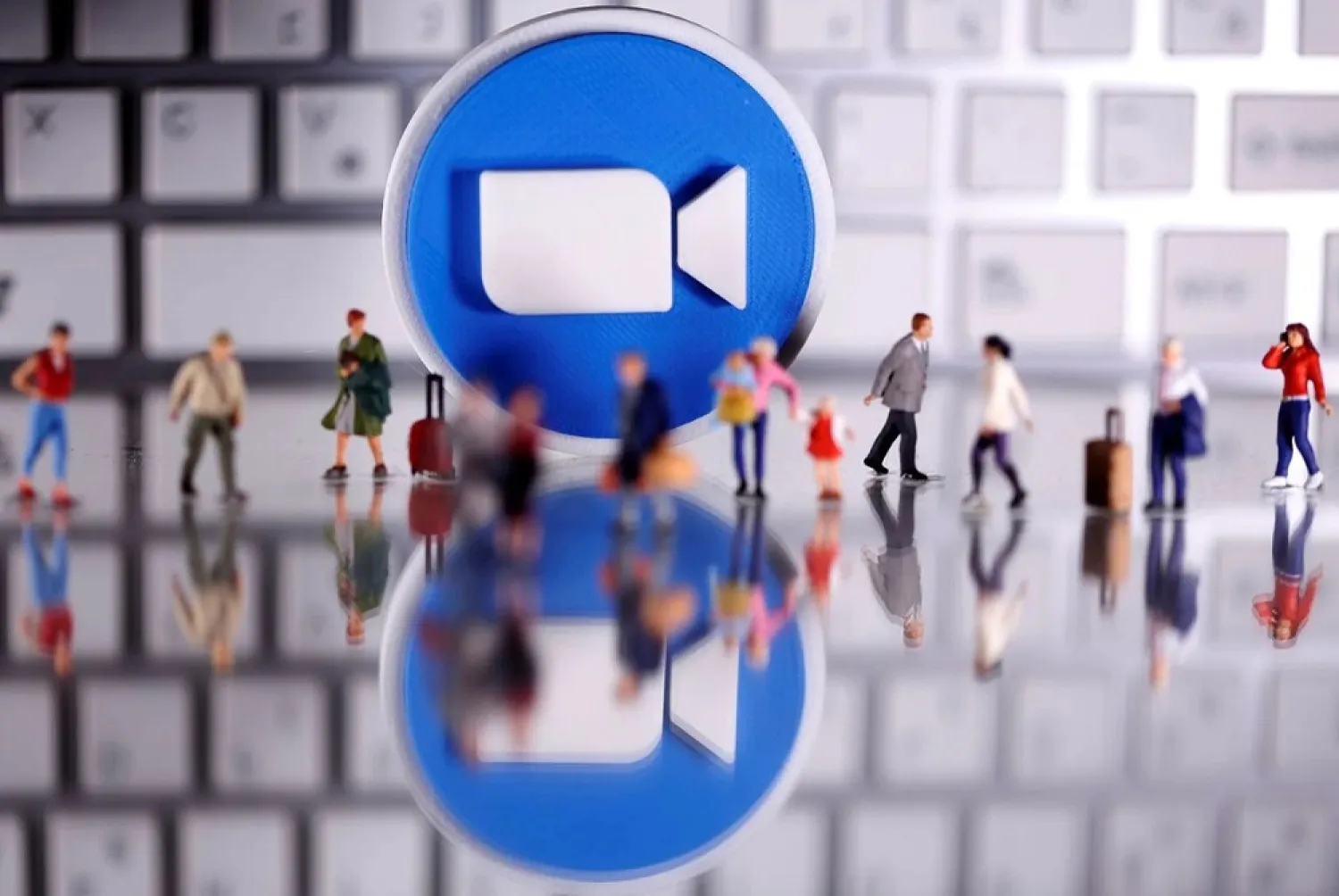A 3D printed Zoom logo is placed between small toy people figures and a keyboard in this illustration taken April 12, 2020. (Reuters)