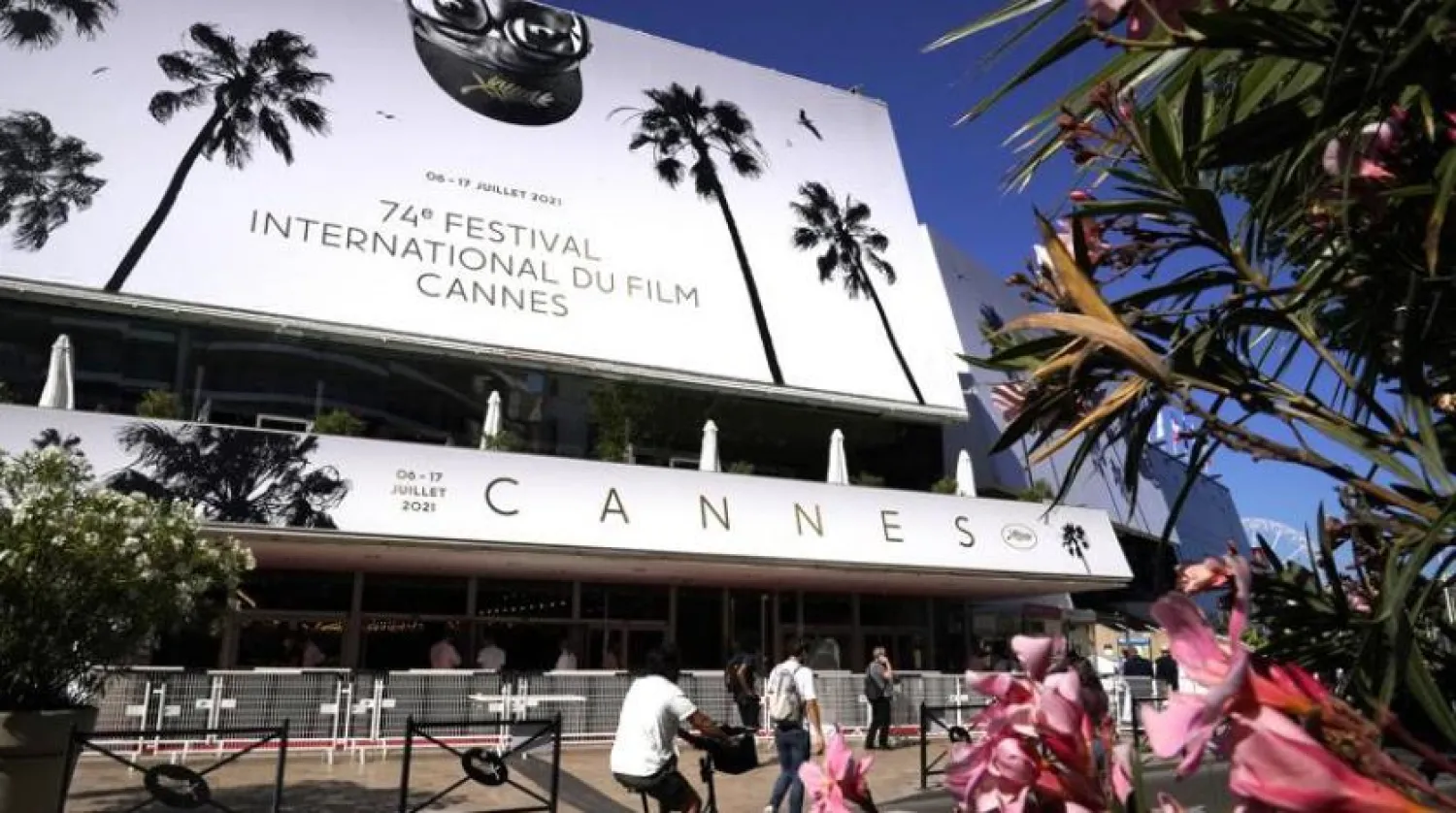 Members of the public walk in front of the Palais des Festival prior to the 74th international film festival, Cannes, southern France, July 5, 2021. The Cannes film festival runs from July 6 - July 17, 2021. (AP Photo/ Brynn Anderson)
