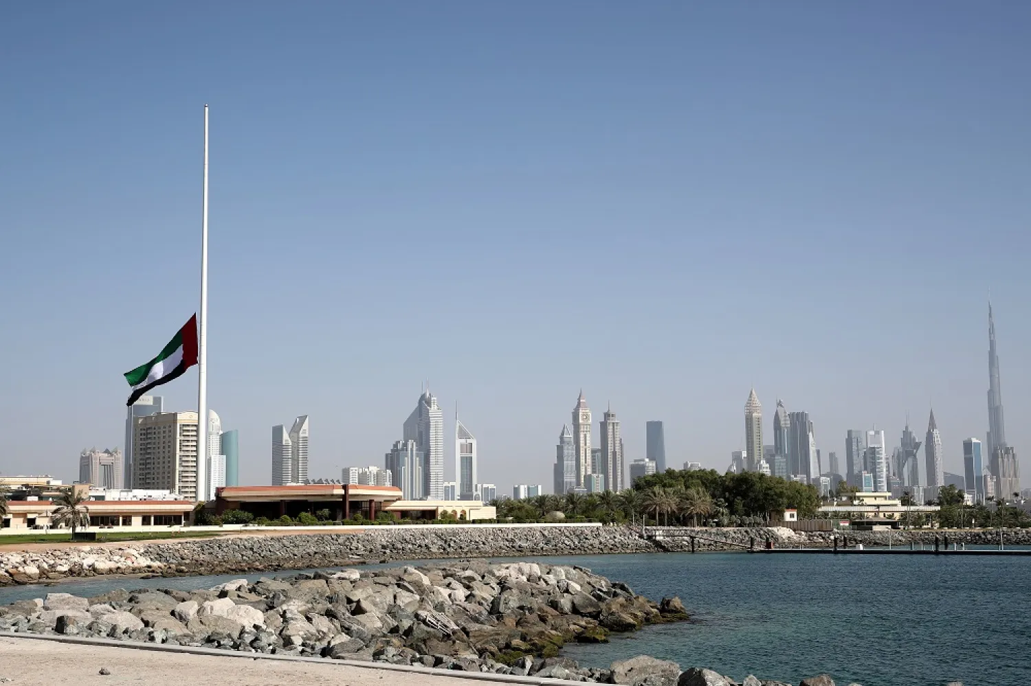 A UAE flag flies at half-mast with backdrop of Burj Khalifa (R) and Dubai buildings as a 40-day official mourning was announced after death of the United Arab Emirates President Sheikh Khalifa bin Zayed Al Nahyan, in Dubai, UAE, 13 May 2022. (EPA)