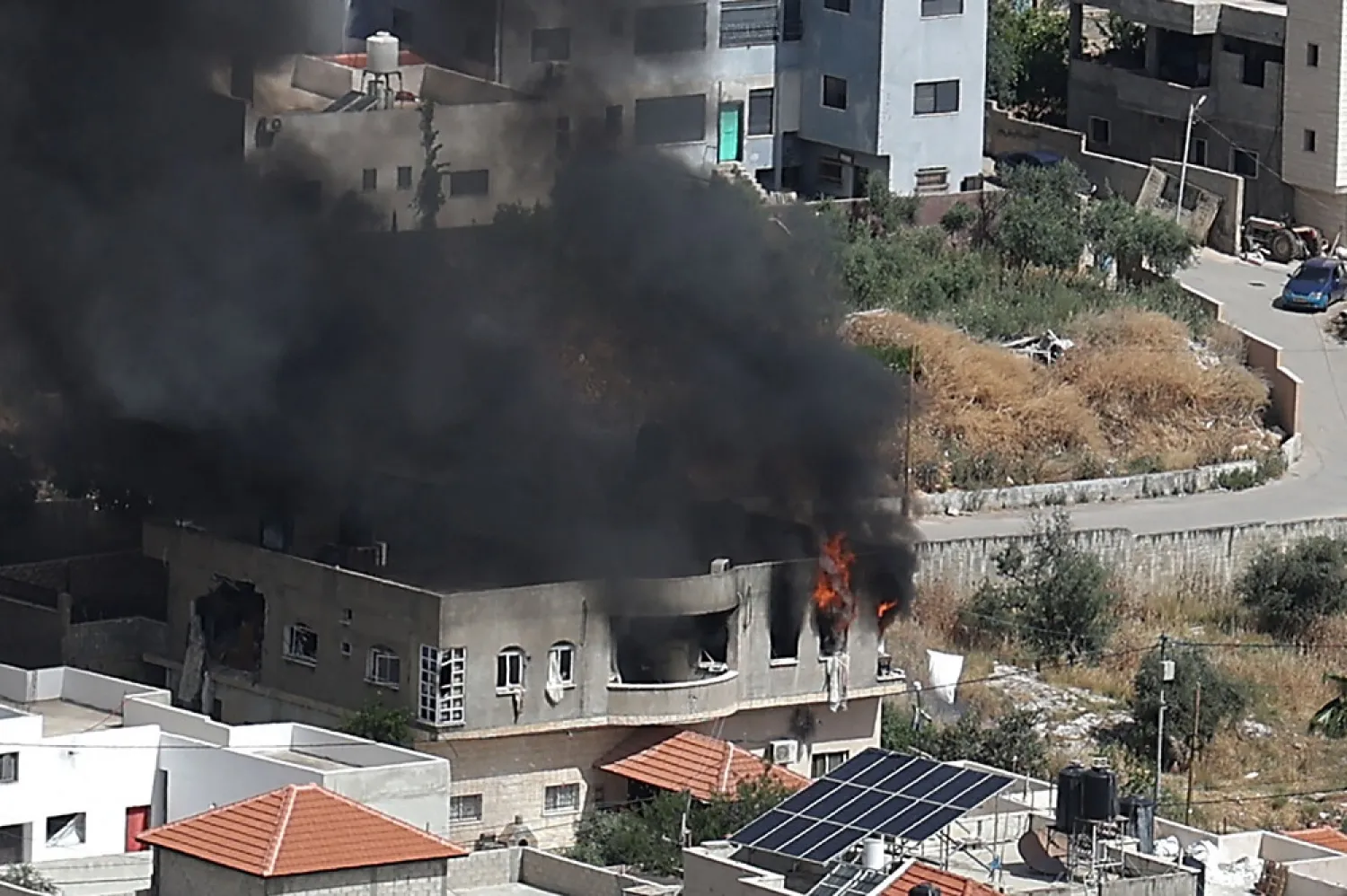 Smoke billows from a building in the Jenin refugee camp on May 13, 2022 during an Israeli military raid. (AFP)