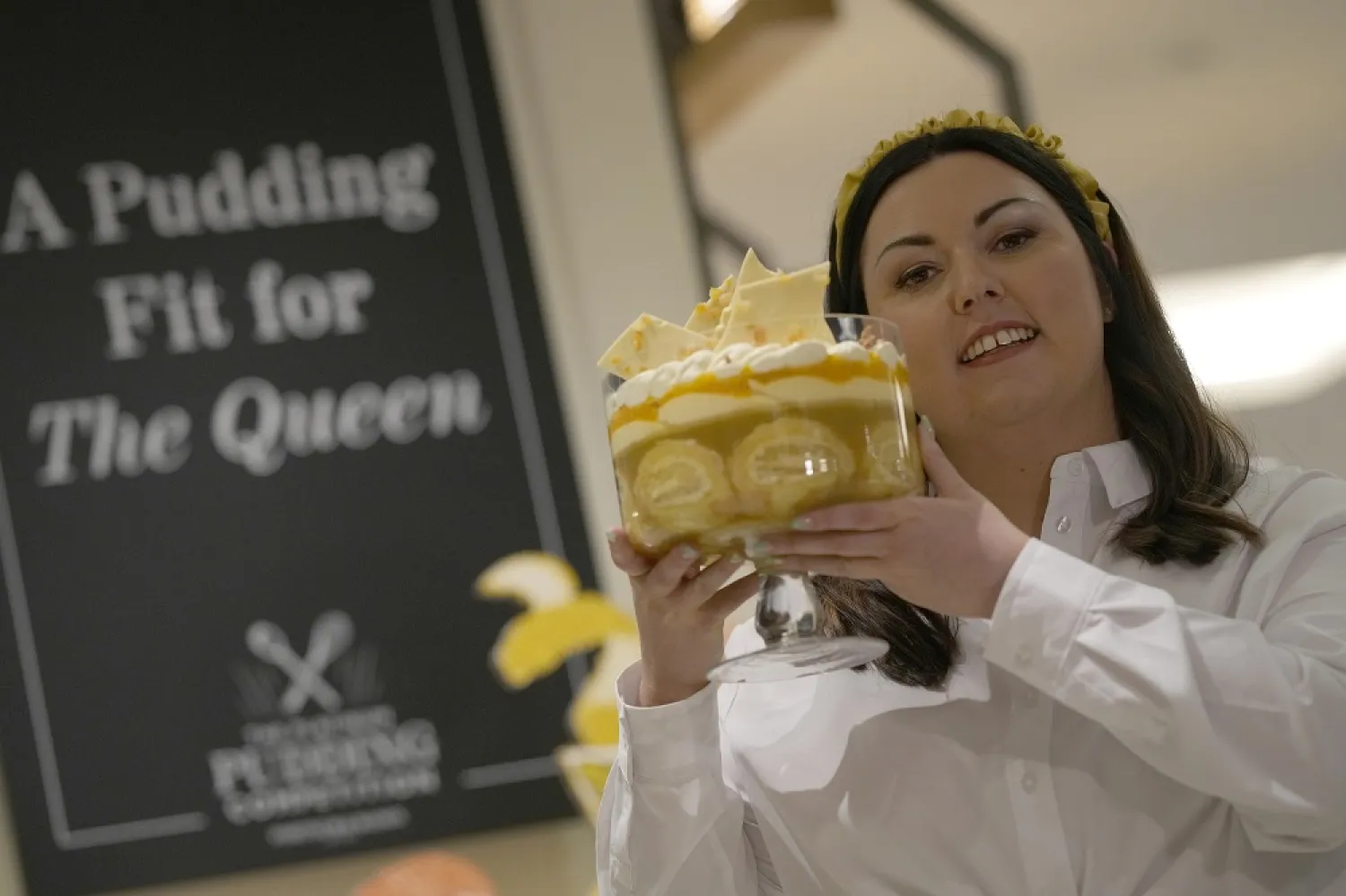 Jemma Melvin the Platinum Jubilee Pudding winner poses for the media with her creation, at a department store in London, Friday, May 13, 2022. Jemma was chosen from over 5000, entries. (AP)