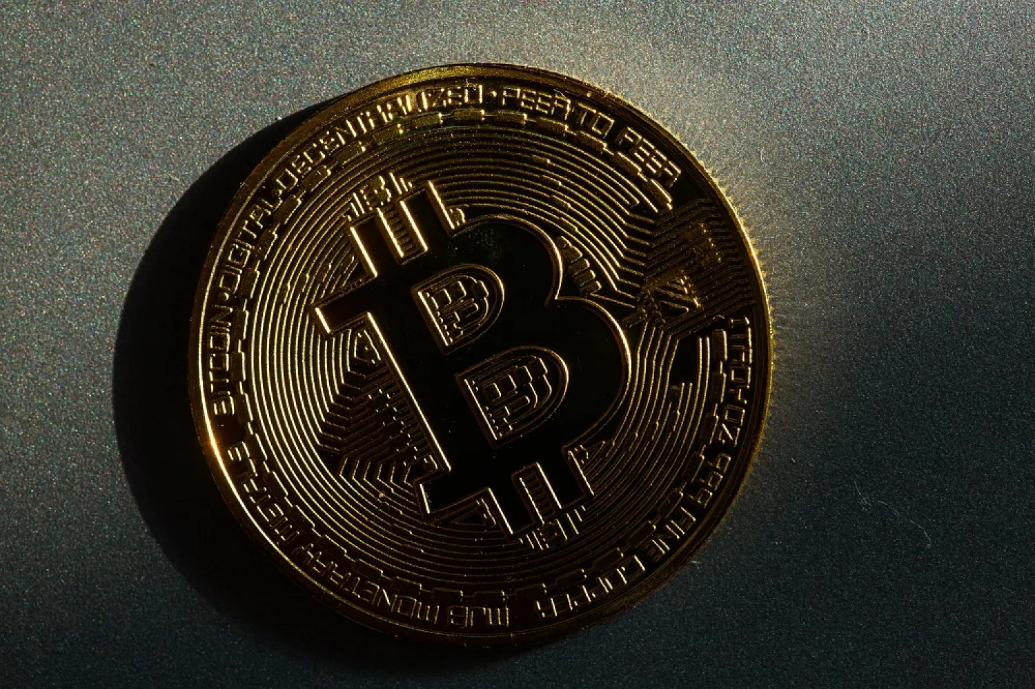 05 March 2022, Berlin: A coin bearing the logo of the bitcoin cryptocurrency lies on a table. (dpa)