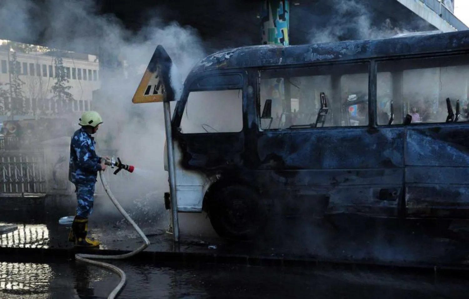 A file photo shows a charred Syrian army bus, that was targeted with explosive devices in the Syrian capital Damascus, October 20, 2021. (SANA/AFP)
