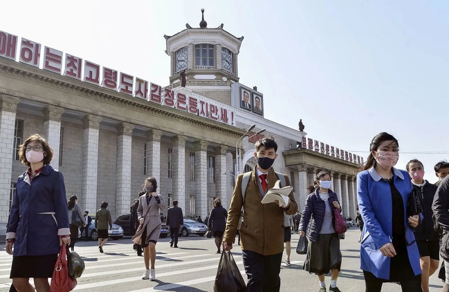 People wearing protective face masks walk amid concerns over the new coronavirus disease (COVID-19) in front of Pyongyang Station in Pyongyang, North Korea April 27, 2020, in this photo released by Kyodo. Kyodo/via Reuters/File Photo