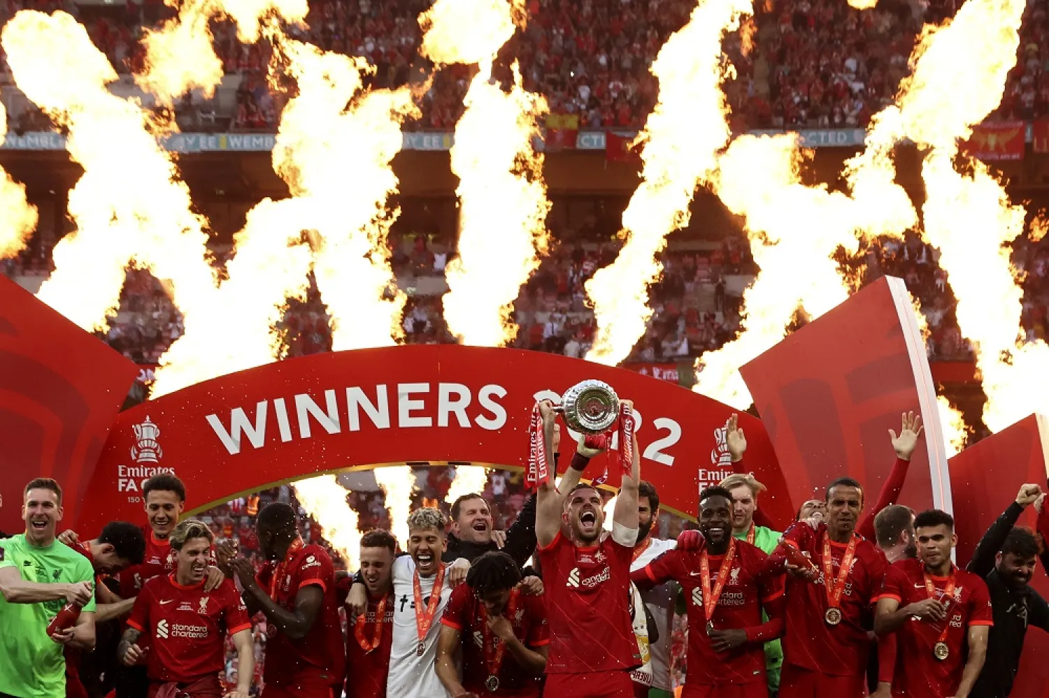Liverpool's Jordan Henderson lifts the trophy after wining the English FA Cup final match between Chelsea and Liverpool, at Wembley stadium, in London, Saturday, May 14, 2022. (AP)