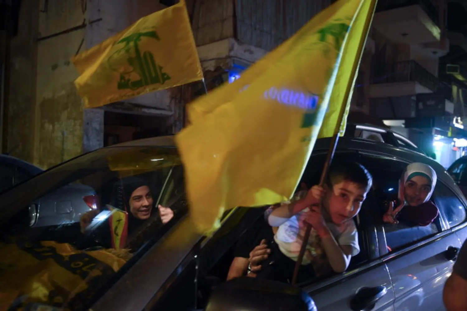 أشخاص يحملون أعلام «حزب الله» في بيروت (إ.ب.أ)