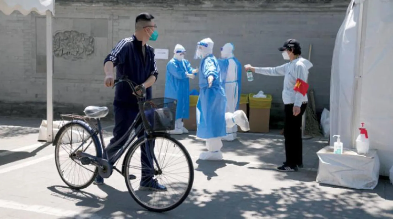 Dün Pekin’deki geçici bir test alanda sterilizasyon yapan çalışanlar (AP)