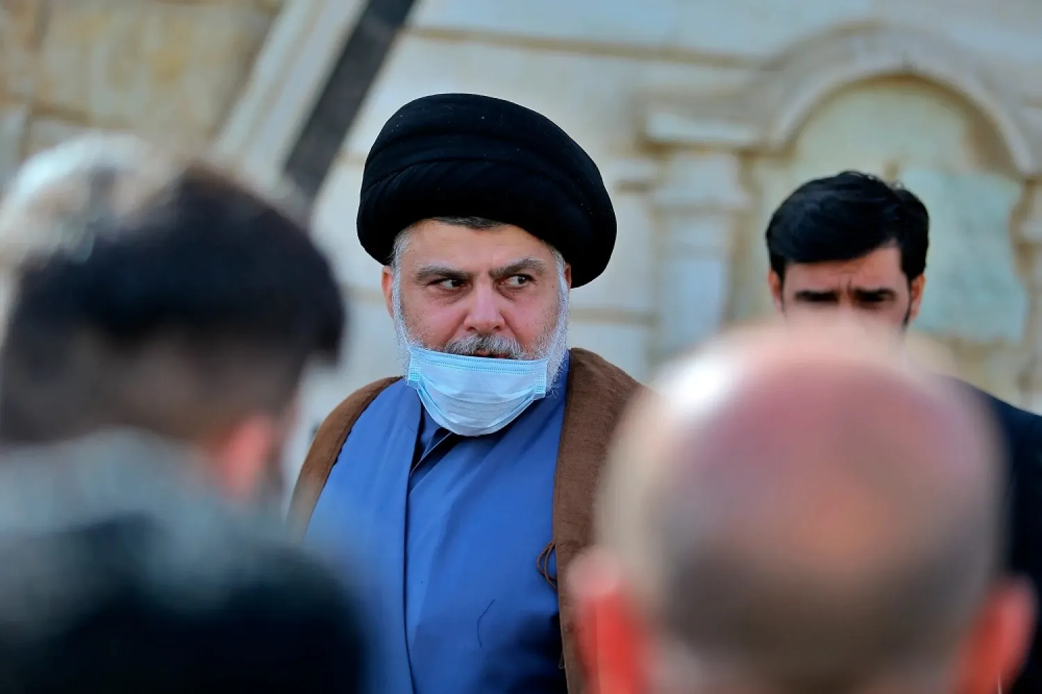 Moqtada al-Sadr, center, leaves a news conference in Najaf, Iraq, Wednesday, Feb. 10, 2021. (AP)