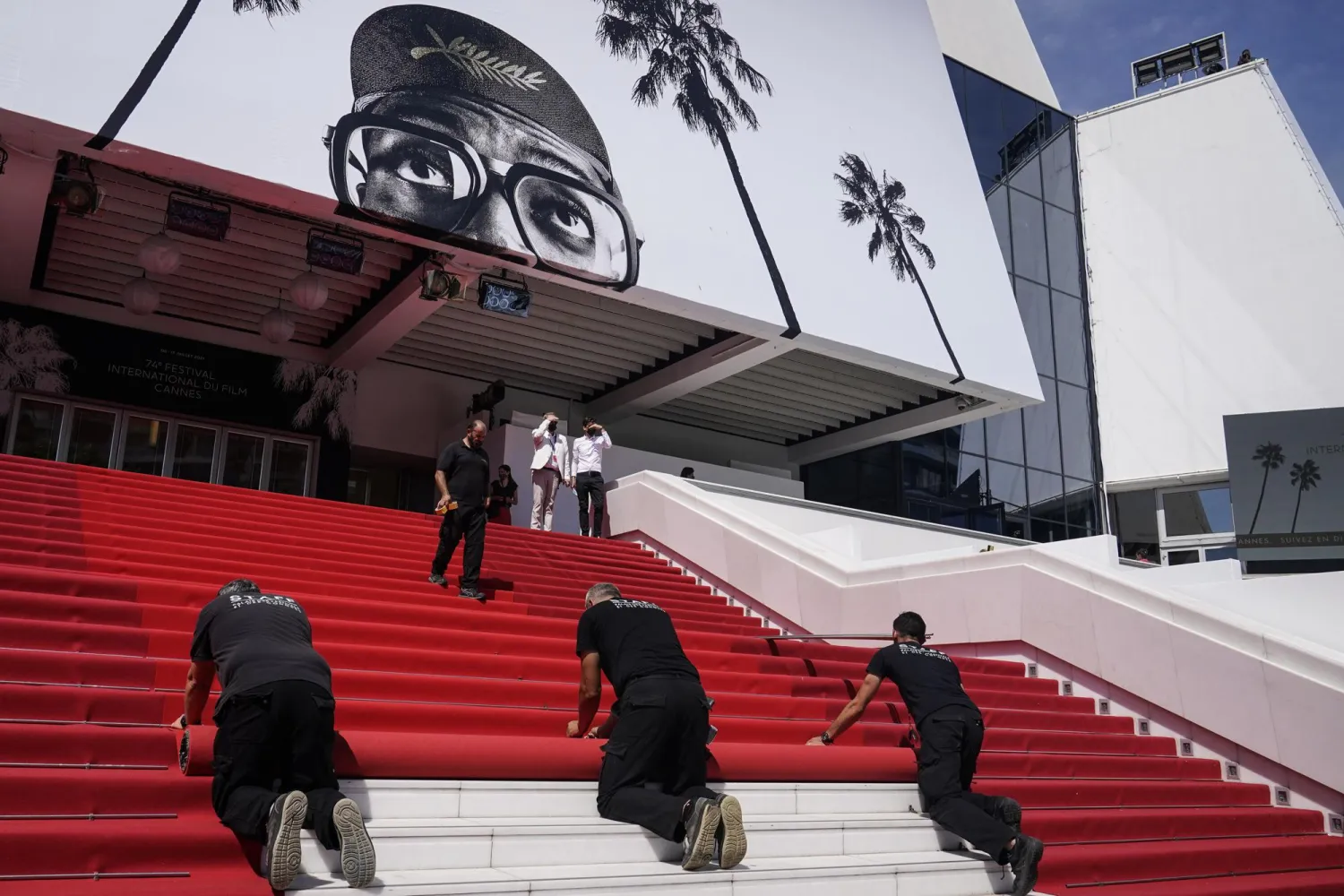 Crew members install the red carpet at the Palais des Festival ahead of the opening day of the 74th international film festival.(AP Photo/Brynn Anderson, File)
