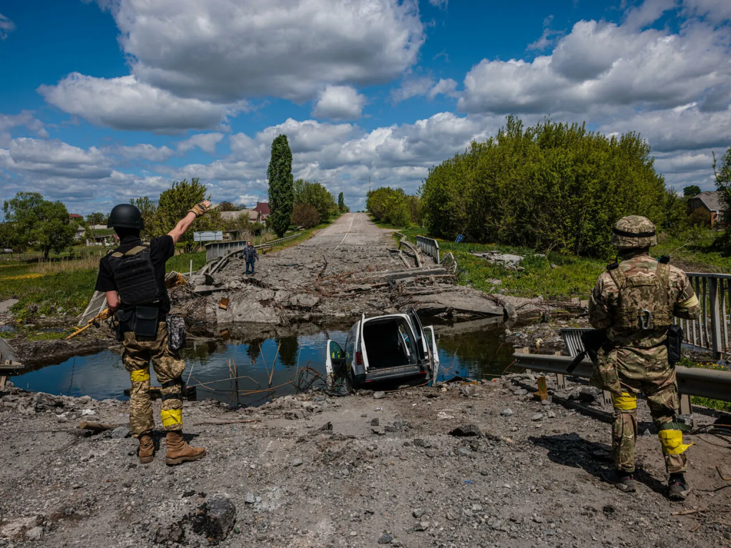 Soldiers of the Kraken Ukrainian special forces unit talk to a man at a destroyed bridge near the village of Ruska Lozova, north of Kharkiv Dimitar DILKOFF AFP

