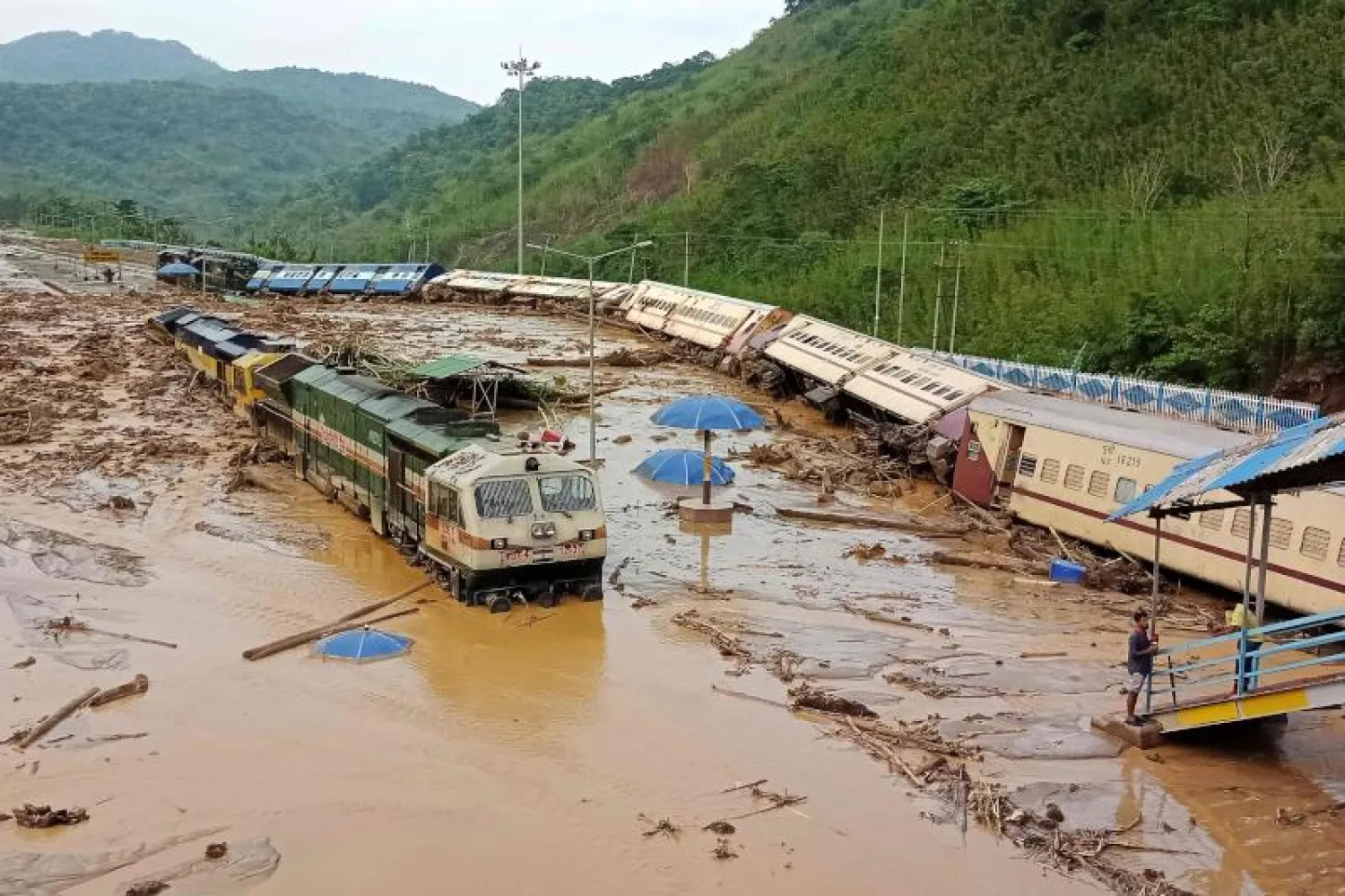 عربات قطارات سقطت بعد الانهيار الأرضي الناجم عن هطول أمطار غزيرة في محطة سكة حديد بالهند (أ.ف.ب)