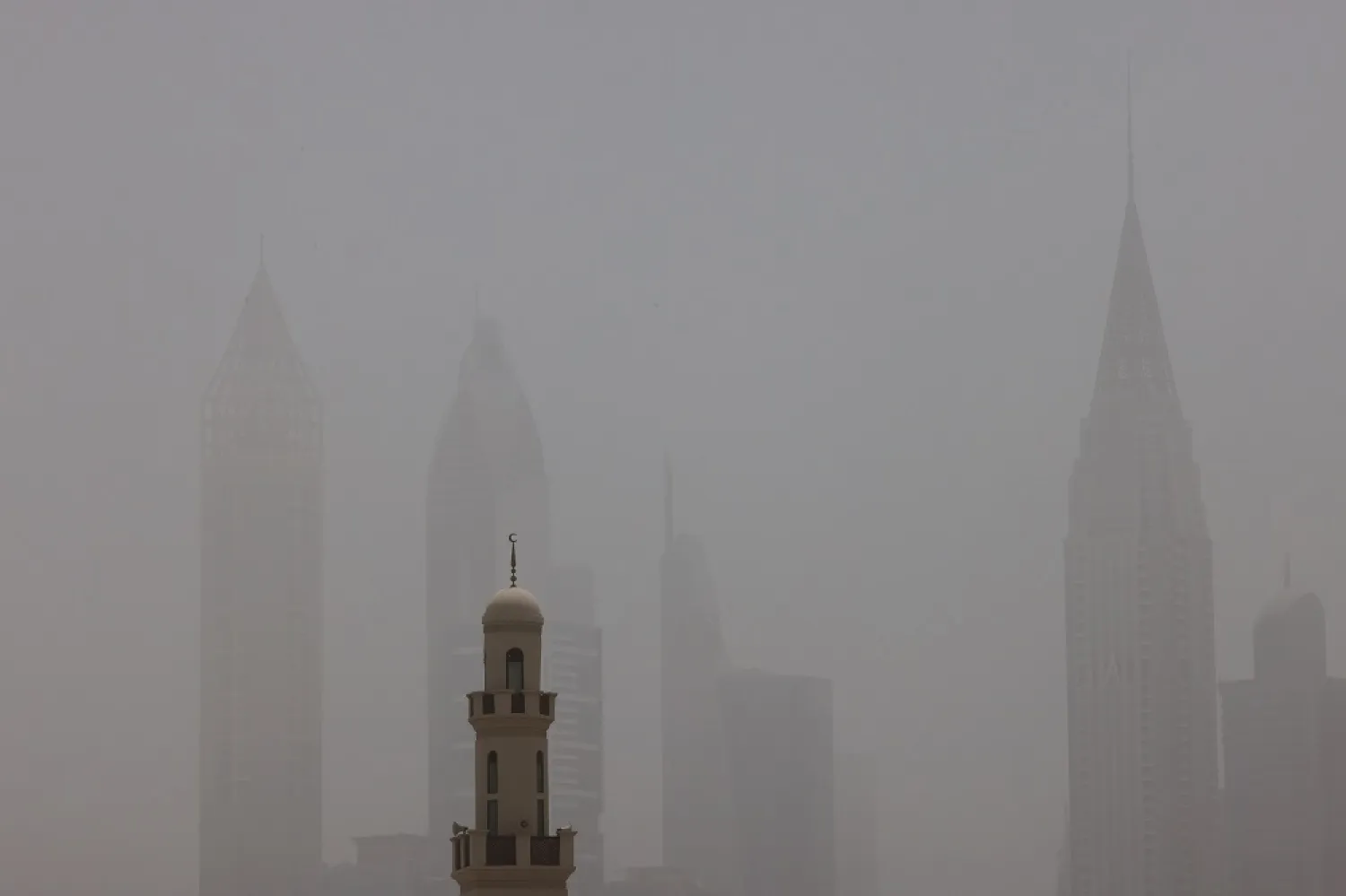 This picture taken on May 18, 2022 shows a view of the haze obscuring the skyline of the Gulf emirate of Dubai with a mosque in the foreground during a heavy sandstorm. (AFP)