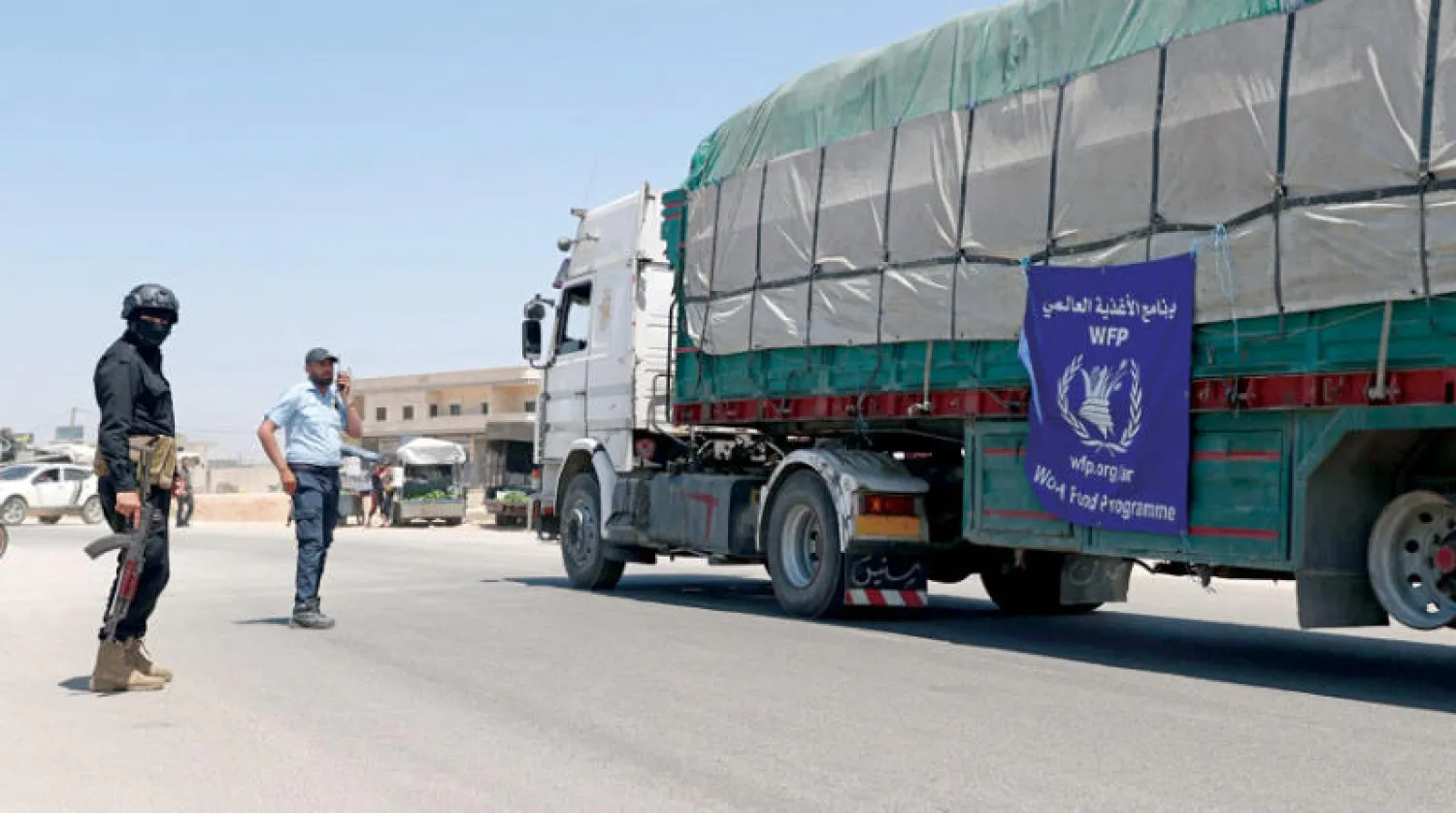 شاحنة مساعدات من برنامج الأغذية العالمي خلال عبورها بلدة حزانو بريف إدلب الاثنين (أ.ف.ب)