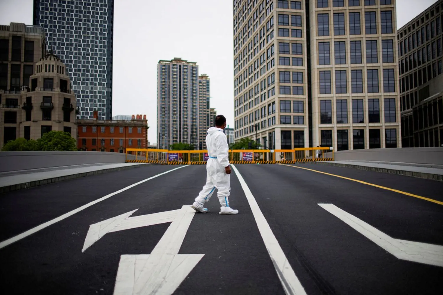 A worker in a protective suit walks on a closed bridge during lockdown, amid the coronavirus disease (COVID-19) outbreak, in Shanghai, China, May 18, 2022. REUTERS/Aly Song/File Photo


