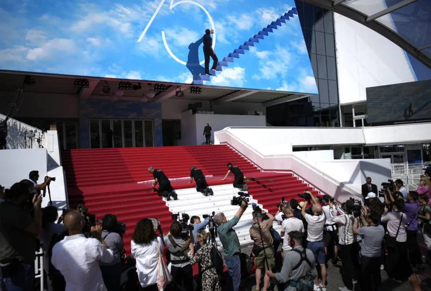 Crew members install the red carpet at the Palais des Festivals, ahead of the opening day of the 75th Cannes Film Festival. (AP)