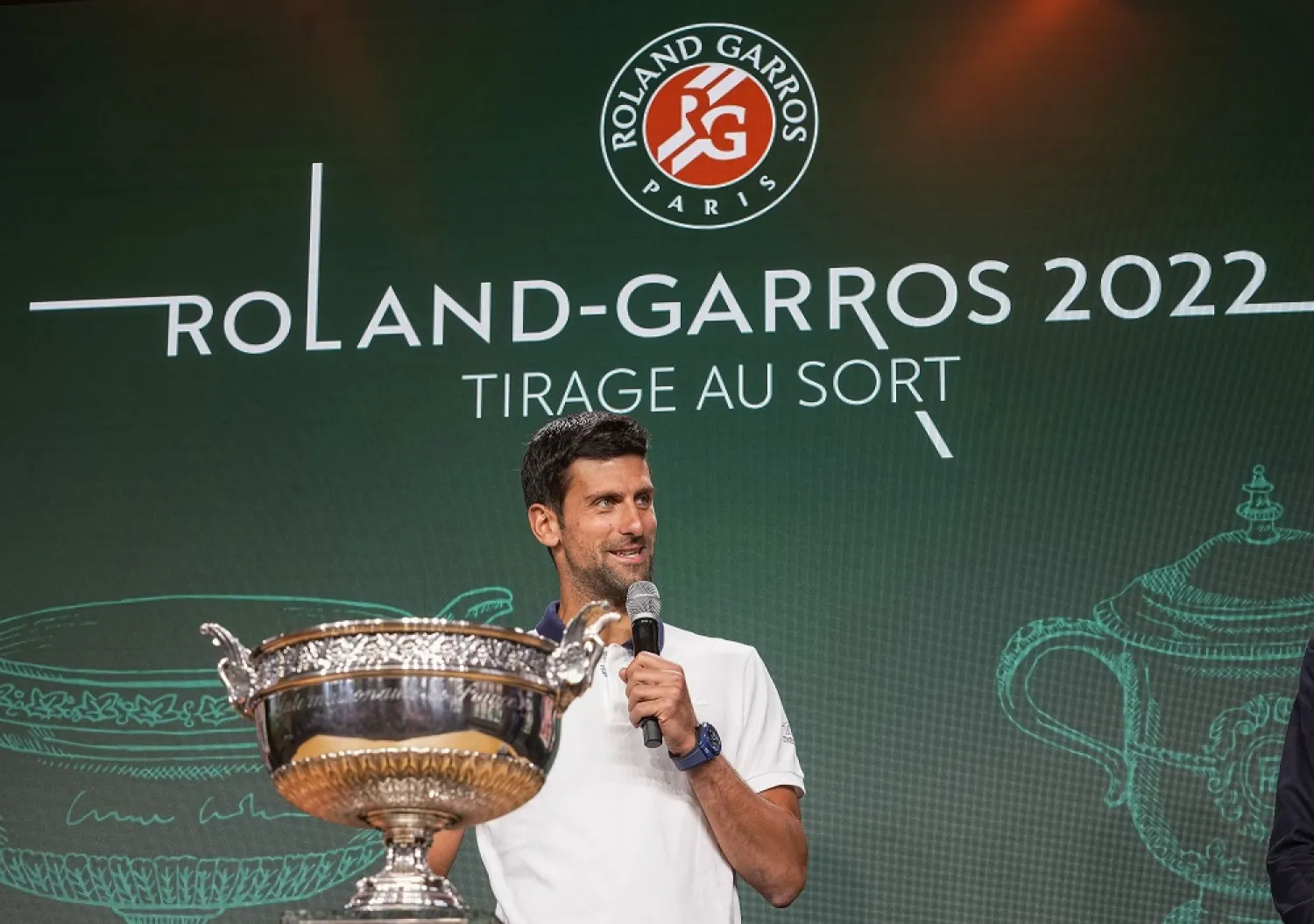 Defending champion Serbia's Novak Djokovic speaks next to the cup during the draw of the French Open tennis tournament at the Roland Garros stadium in Paris, Thursday, May 19, 2022. (AP)