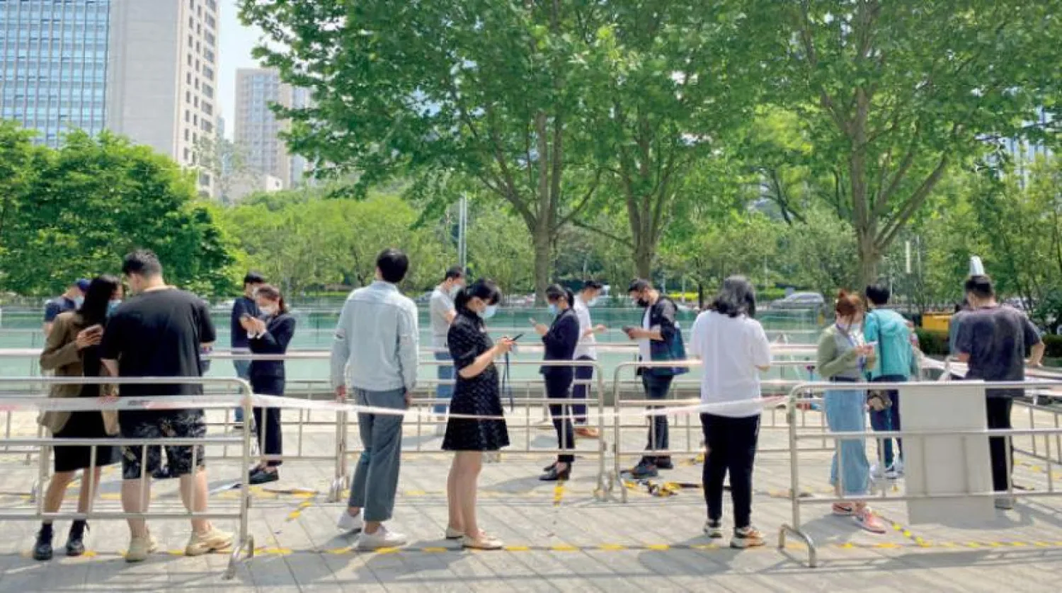 Çin halkı Pekin'deki virüs test sahasında koronavirüs için kuyruğa girerken (AP)