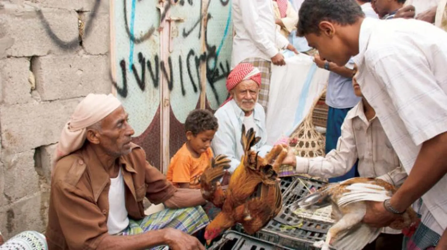 A file photo shows a street vendor showing his chicken to a man in Hodeidah. (Getty Images)