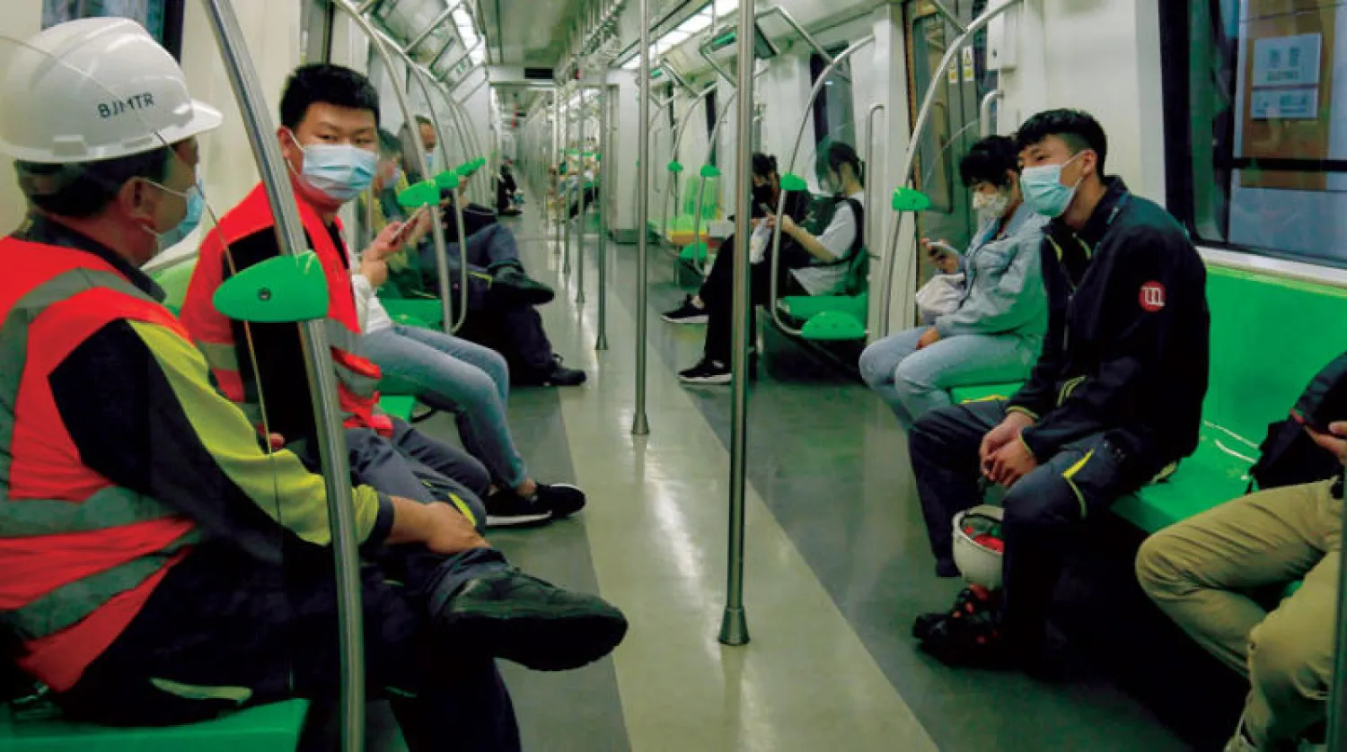 عمال يرتدون كمامات في مترو انفاق بكين أمس (إ.ب.أ)