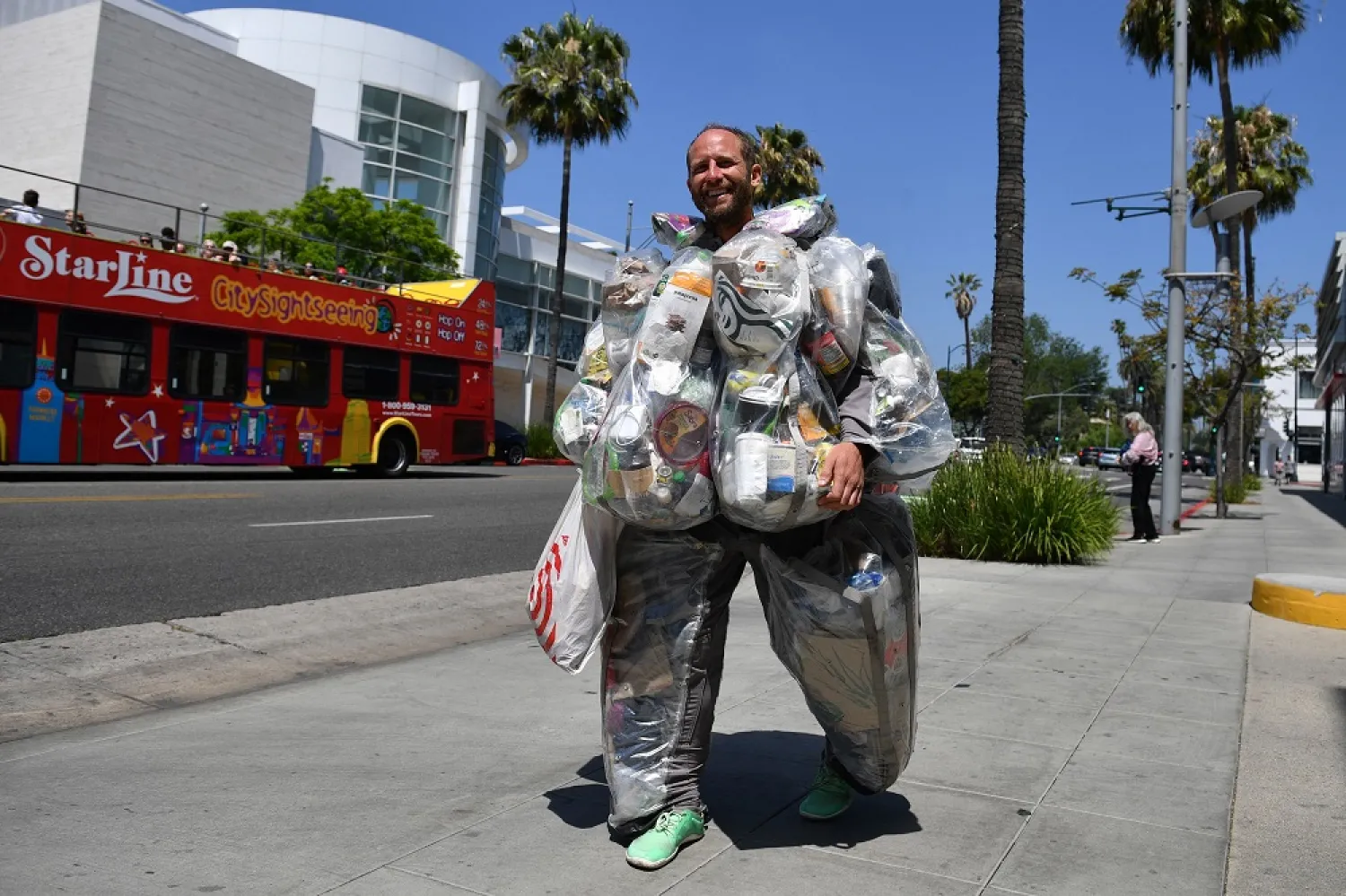 Environmental activist Rob Greenfield walks around Beverly Hills, California May 16, 2022 wearing a suit filled with every piece of trash he has generated living and consuming like a typical American for one month to raise awareness about how much garbage just one person generates. (AFP)