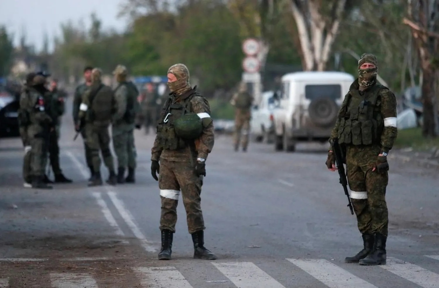 Service members of pro-Russian troops stand guard on a road before the expected evacuation of wounded Ukrainian soldiers from the besieged Azovstal steel mill in the course of Ukraine-Russia conflict in Mariupol, Ukraine May 16, 2022. REUTERS/Alexander Ermochenko



