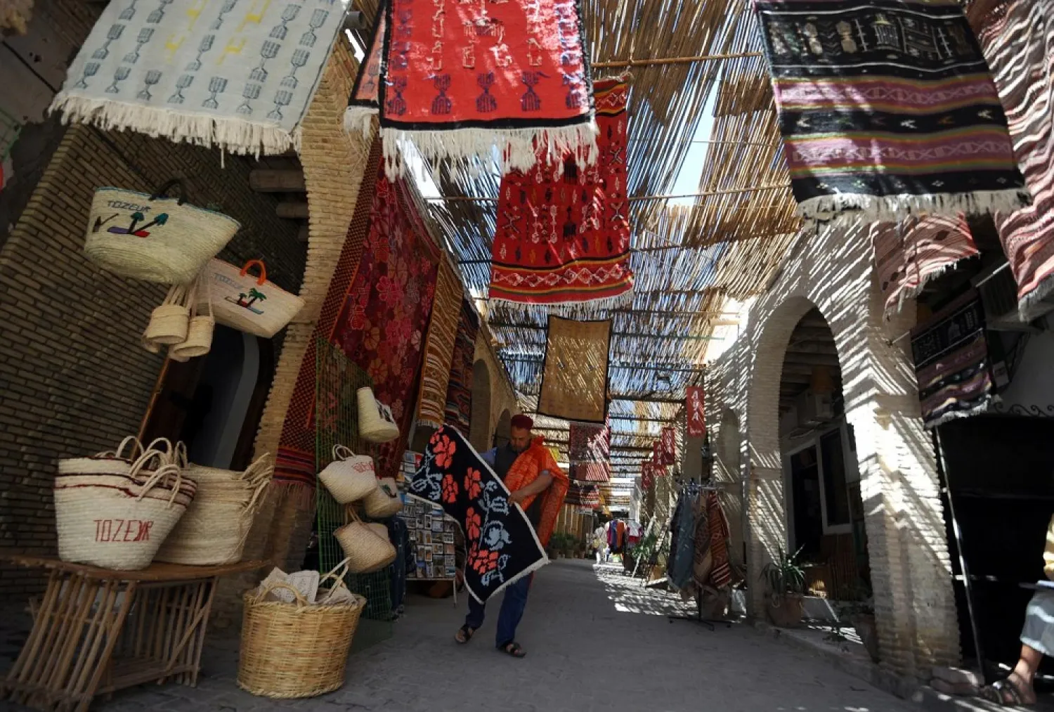 A carpet vendor displays his stock at a traditional market in Tozeur. (AFP file photo)