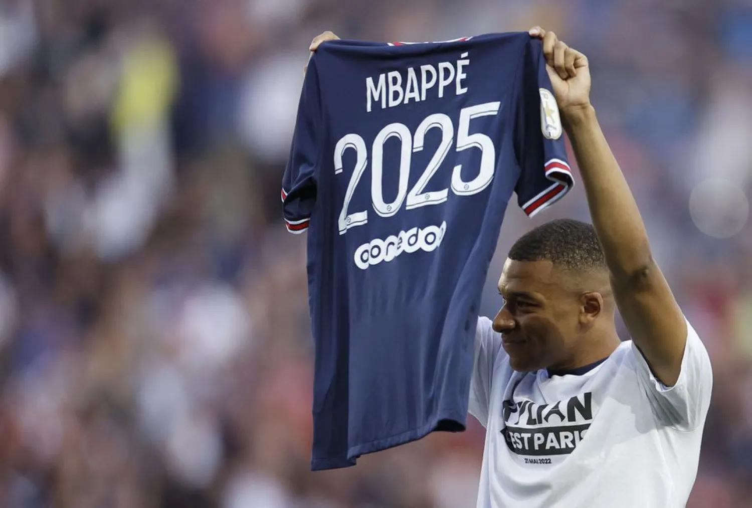 Soccer Football - Ligue 1 - Paris St Germain v Metz - Parc des Princes, Paris, France - May 21, 2022 Paris St Germain's Kylian Mbappe holds up a shirt after signing a new contract REUTERS/Christian Hartmann