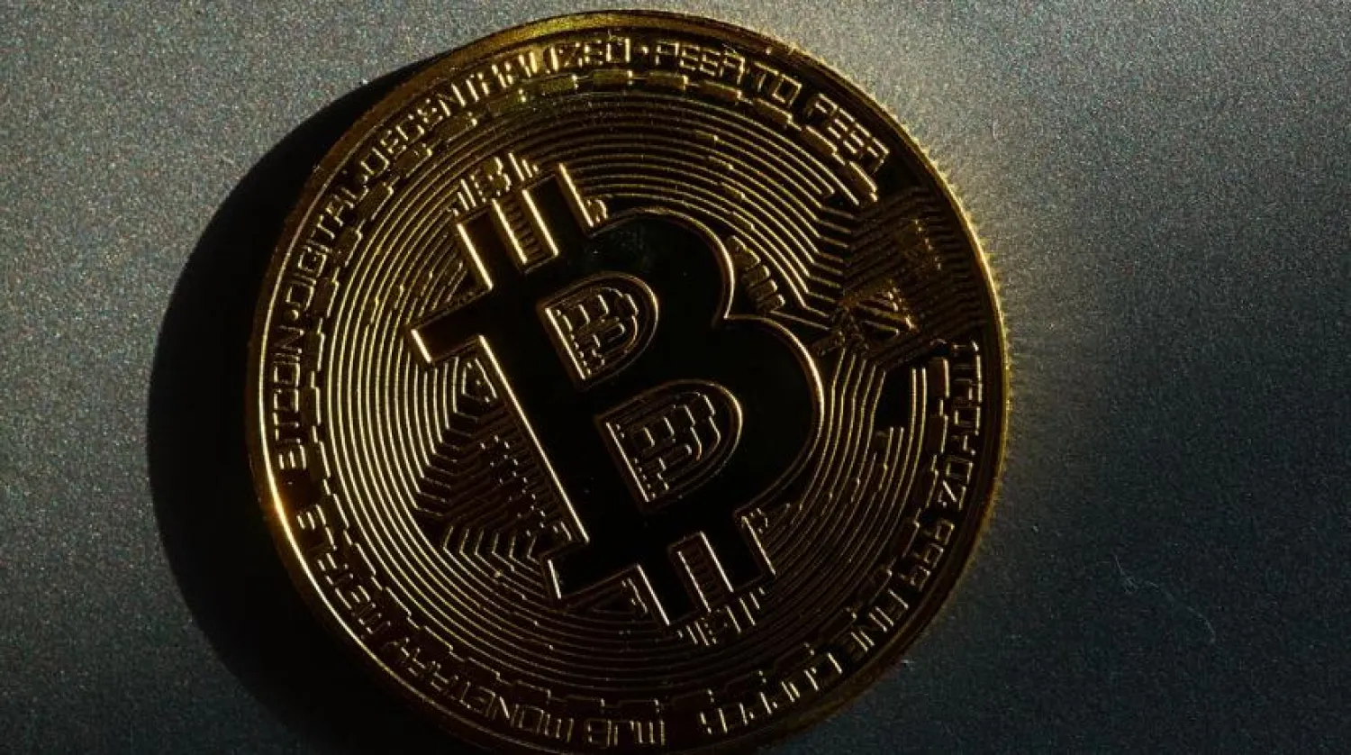 05 March 2022, Berlin: A coin bearing the logo of the bitcoin cryptocurrency lies on a table. (dpa)
