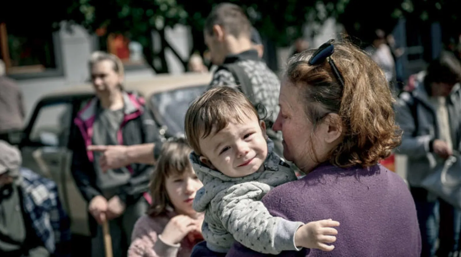 سكان يغادرون مدينة باخموت الواقعة في دونباس بالشرق الأوكراني أمس (أ.ف.ب)