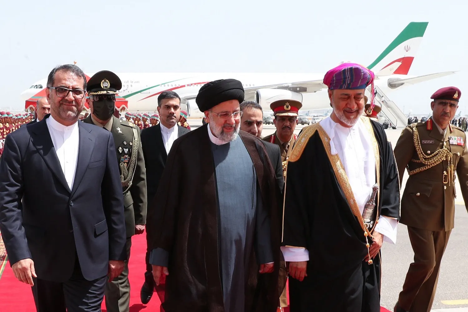 A handout picture provided by the Iranian presidency shows Sultan of Oman Haitham bin Tarik Al Said (C R) welcoming Iran's President Ebrahim Raisi (C L) at the airport in the Omani capital Muscat, on May 23, 2022. (Iranian Presidency/AFP) 